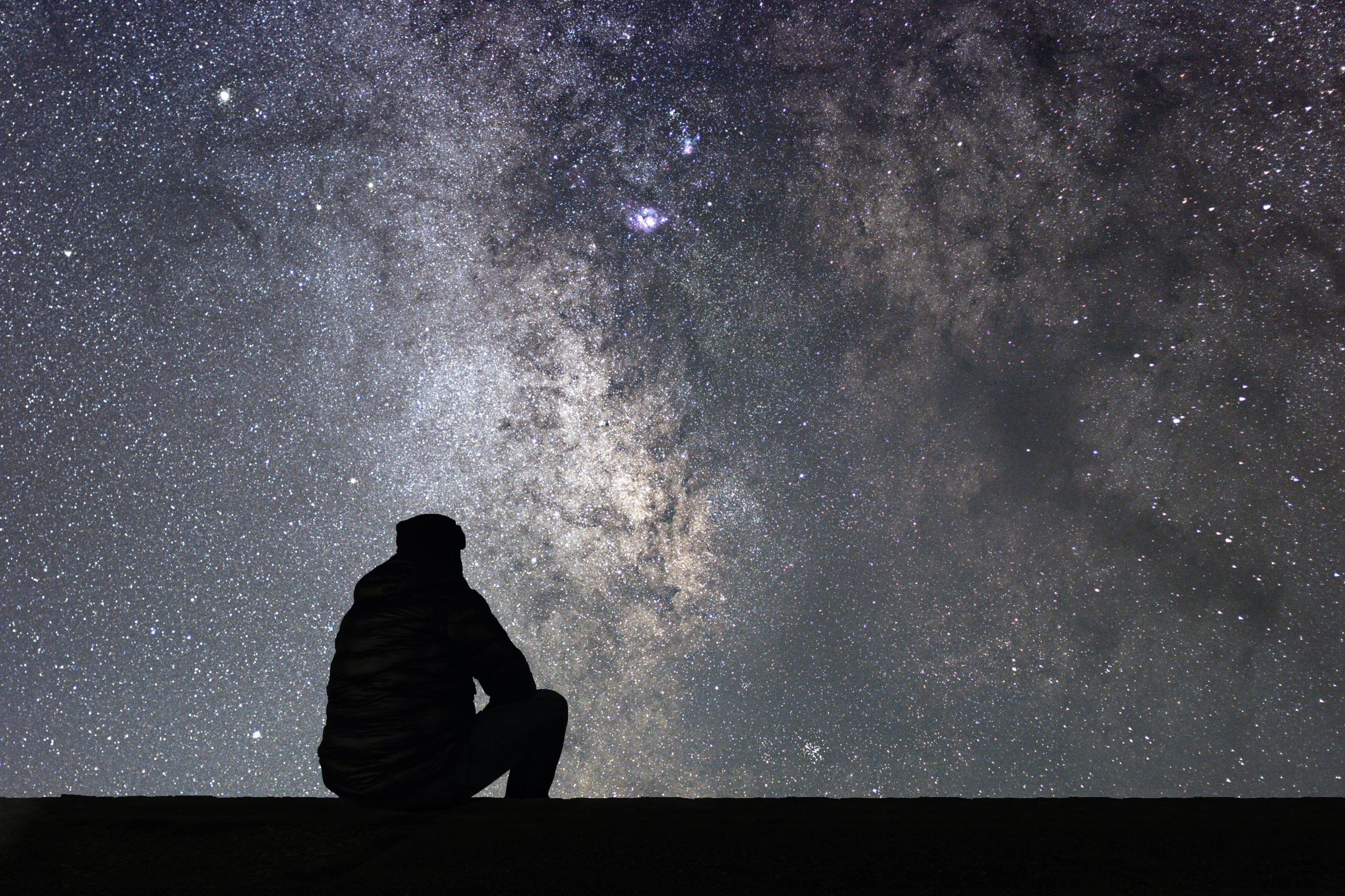 Hombre reflexiona mirando el cielo nocturno estrellado || Fuente: Shutterstock Hombre reflexiona mirando el cielo nocturno estrellado || Fuente: Shutterstock