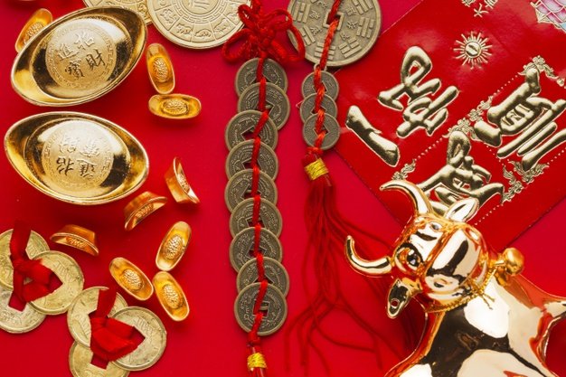 Figura de buey con monedas chinas y objetos dorados.│Foto: Freepik