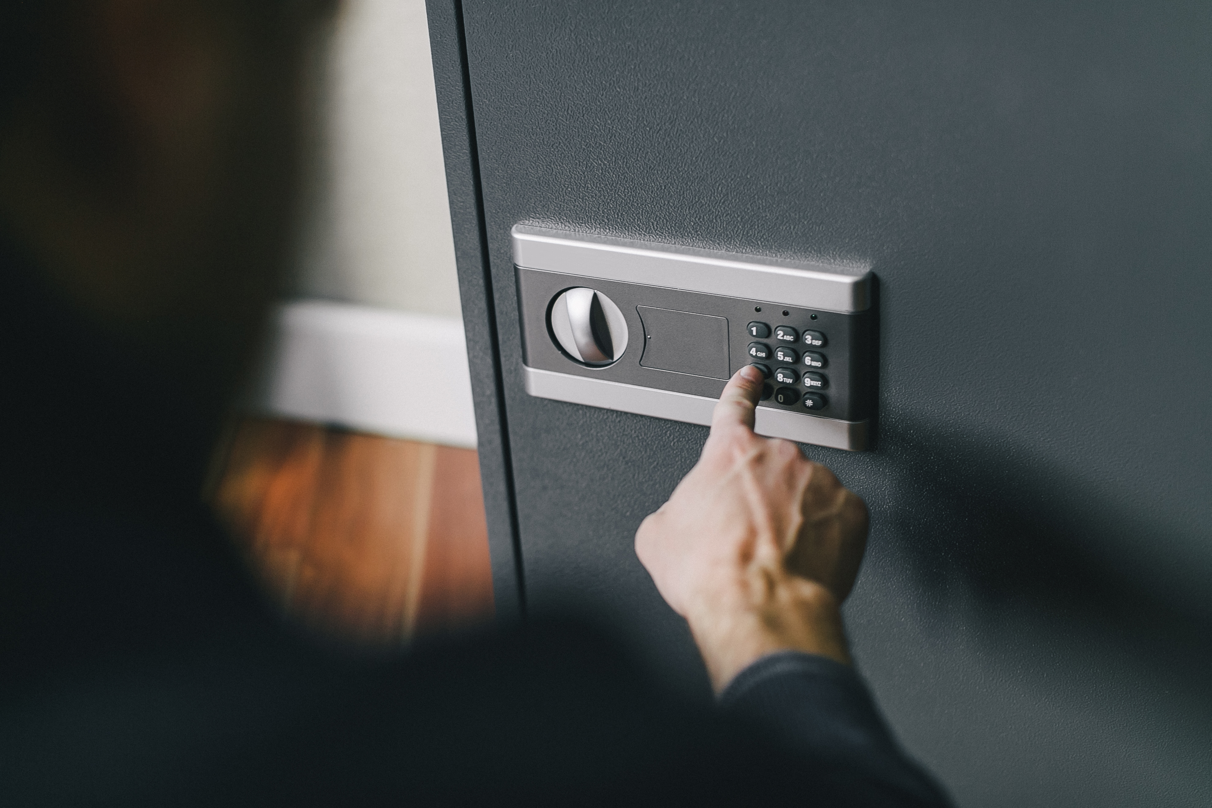 A person entering the passcode using a safe's keypad | Source: Shutterstock
