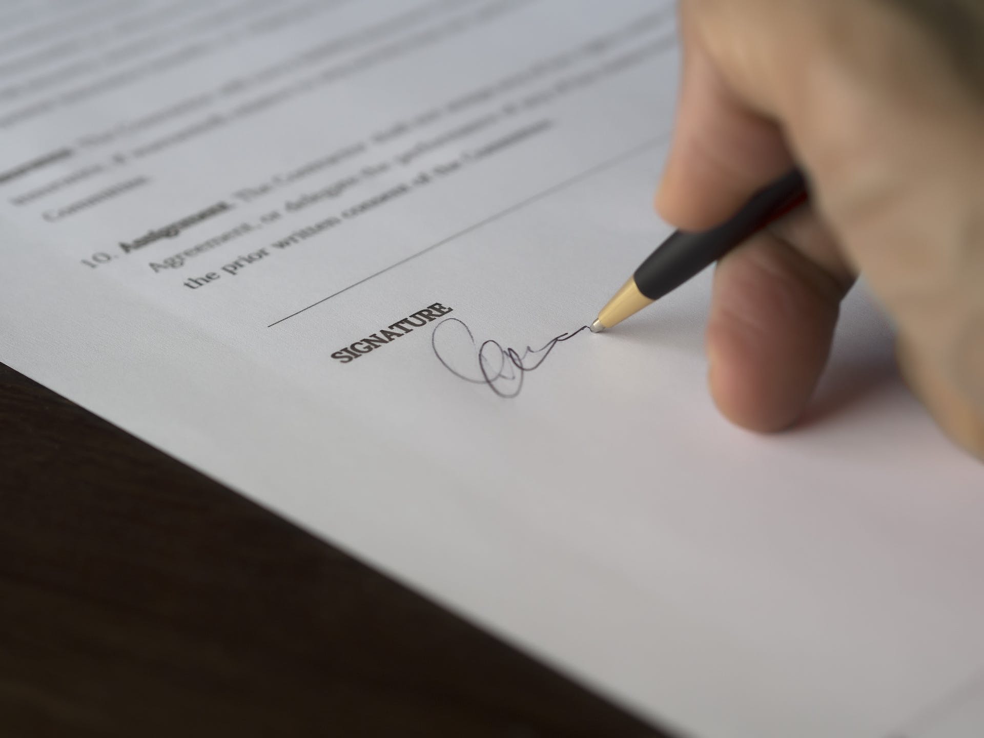 Person signing paperwork | Source: Pexels