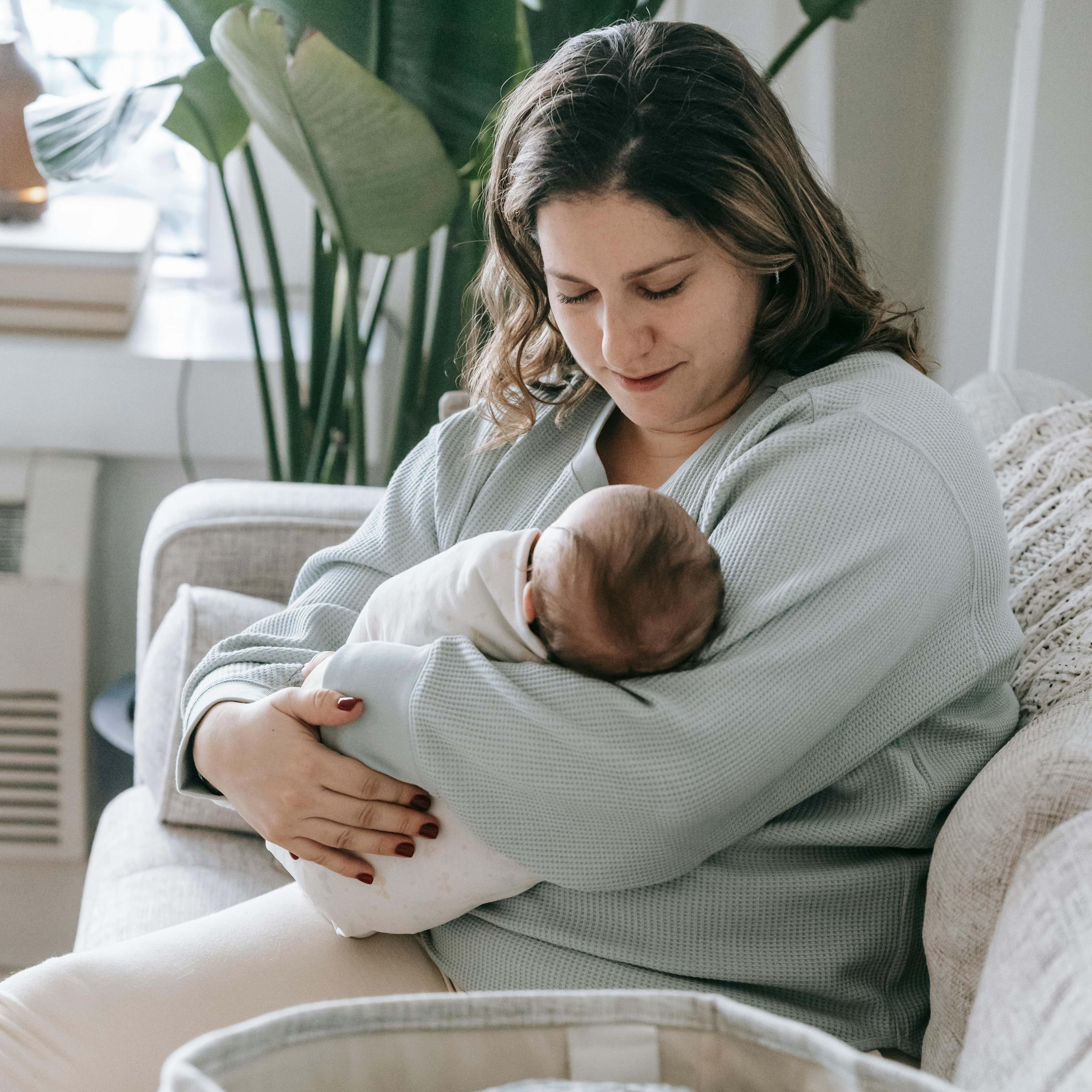 A woman cradling a baby in her arms | Source: Pexels