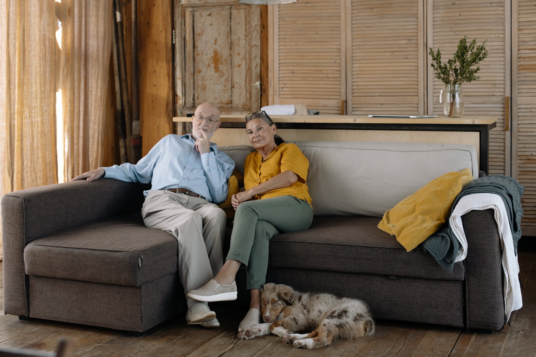 Una pareja de personas mayores y su perro en una sala familiar. | Foto: Pexels