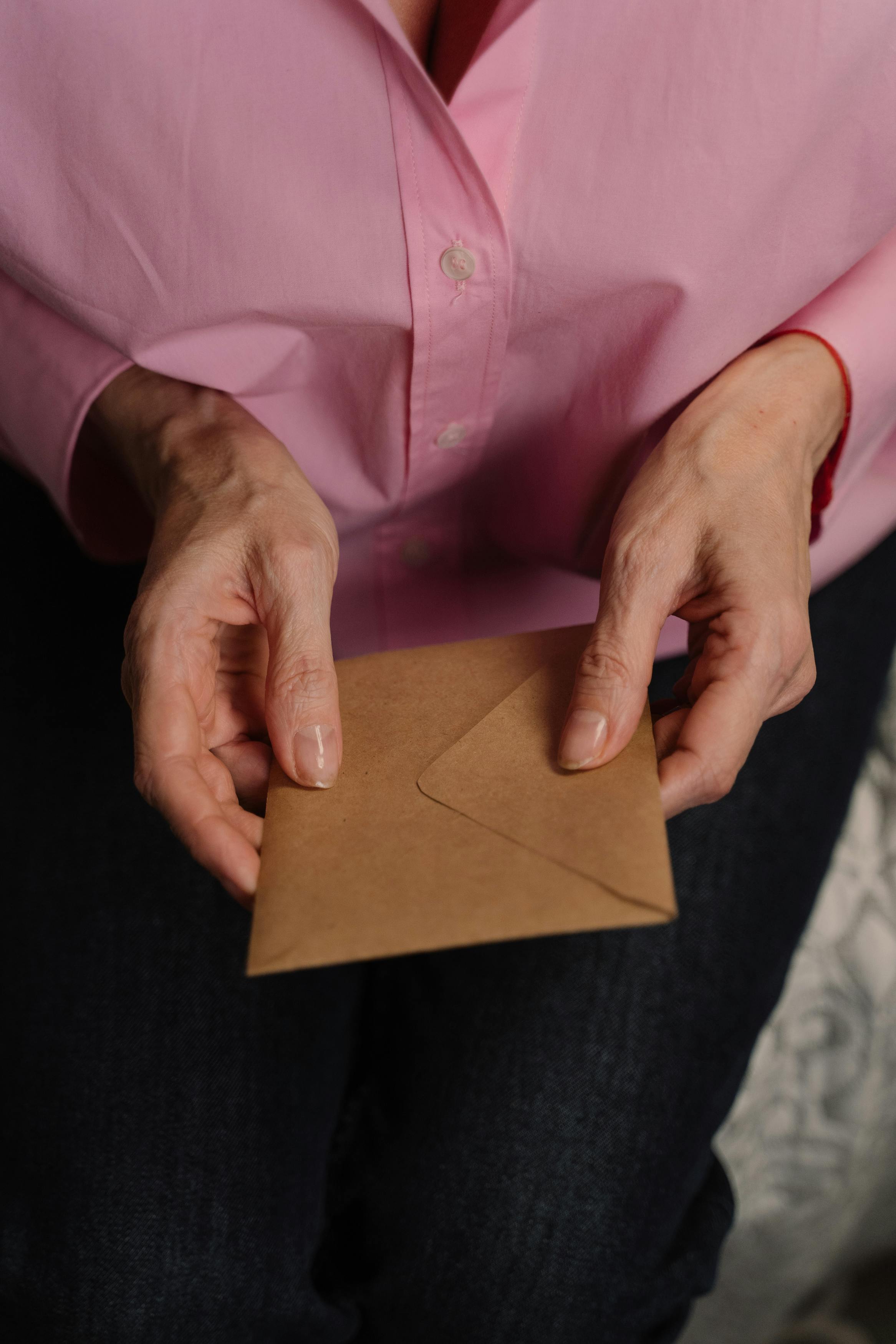 Person holding a brown envelope | Source: Pexels