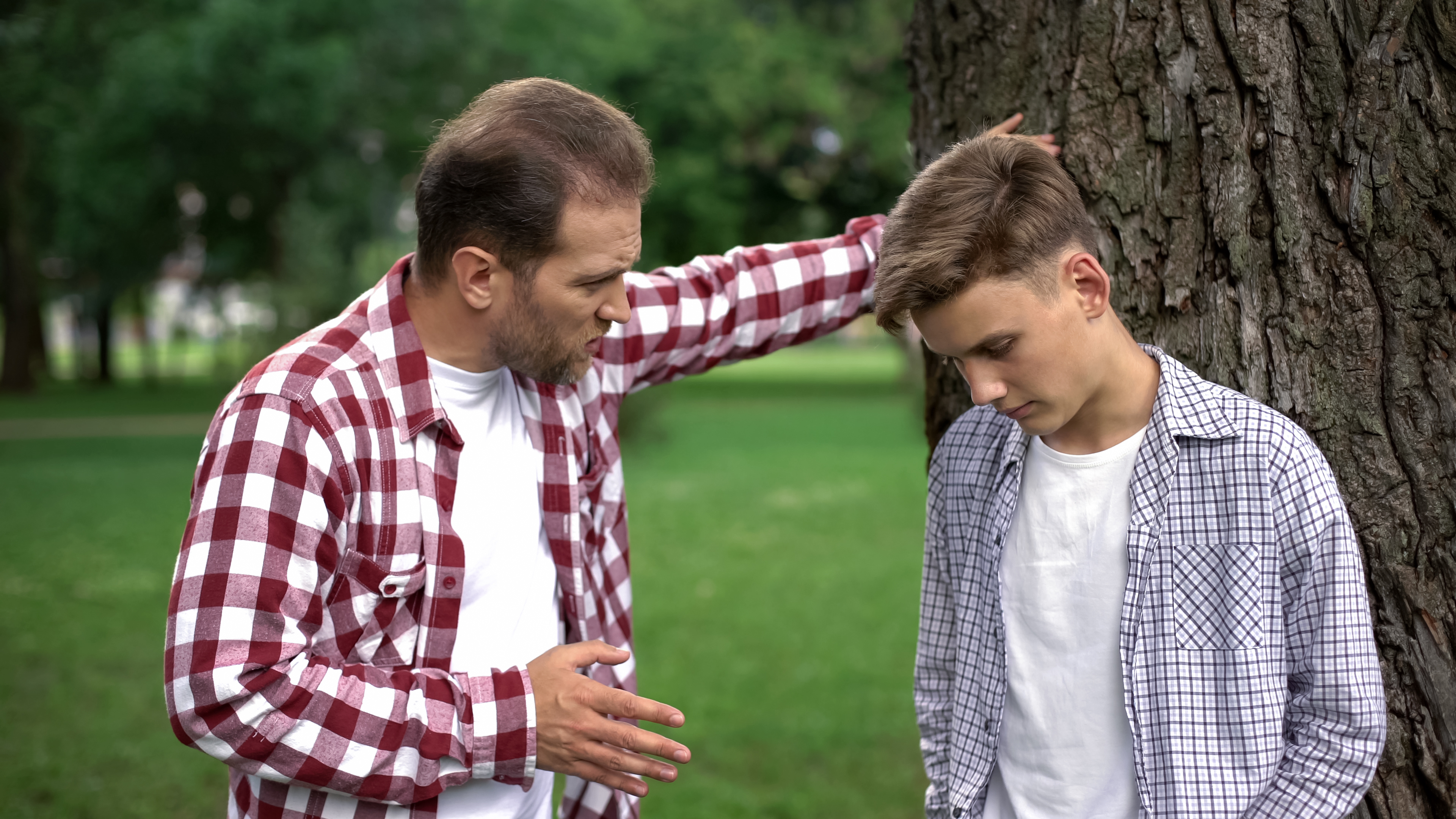 Papá estricto regaña a su hijo por su bajo rendimiento académico. | Foto: Shutterstock