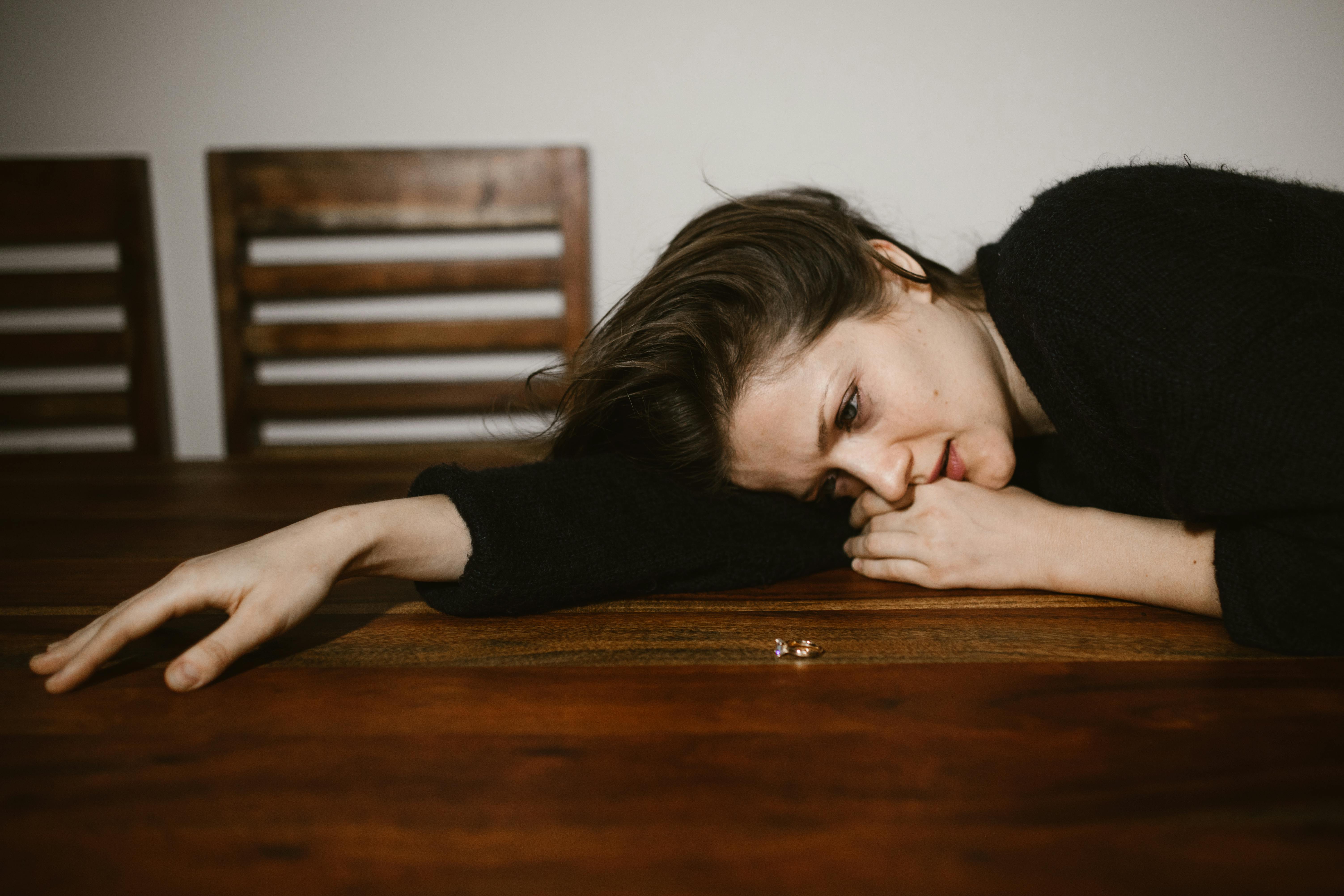 A crying woman leaning on a table | Source: Pexels