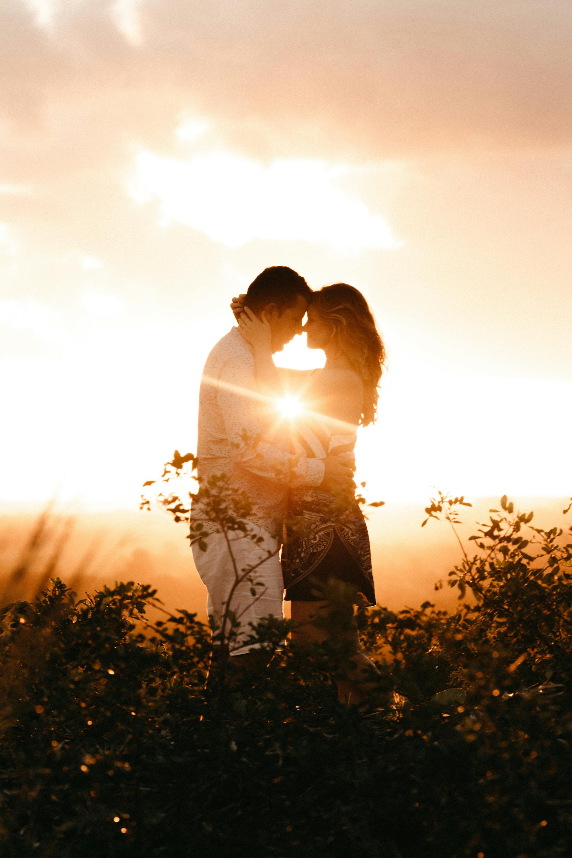 A couple hugging in a field during golden hour | Source: Pexels