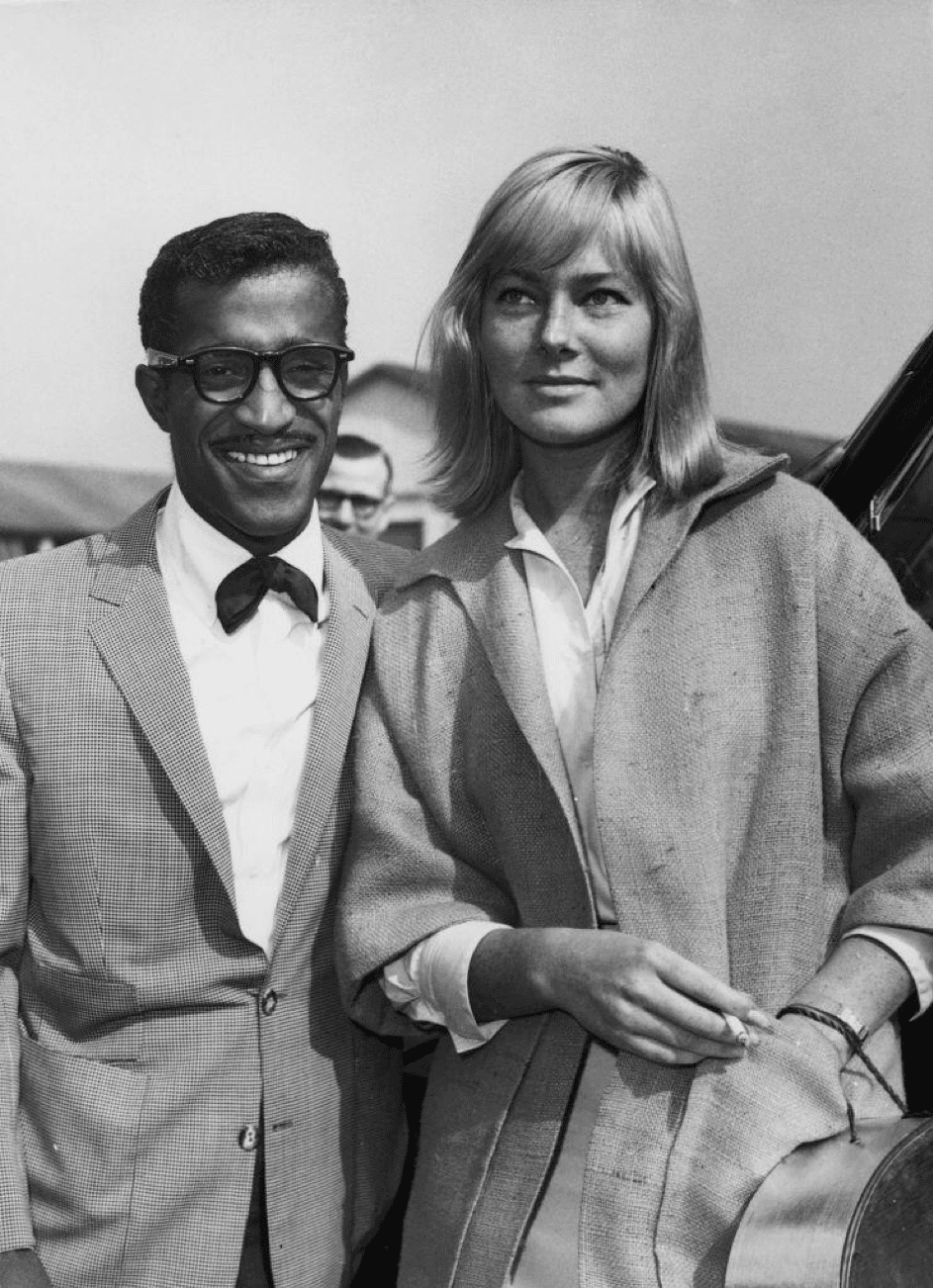 Der amerikanische Sänger, Schauspieler und Tänzer Sammy Davis Jr. (1925-1990) mit seiner zukünftigen Frau, der Schauspielerin May Britt, während eines Besuchs in London. | Quelle: Getty Images