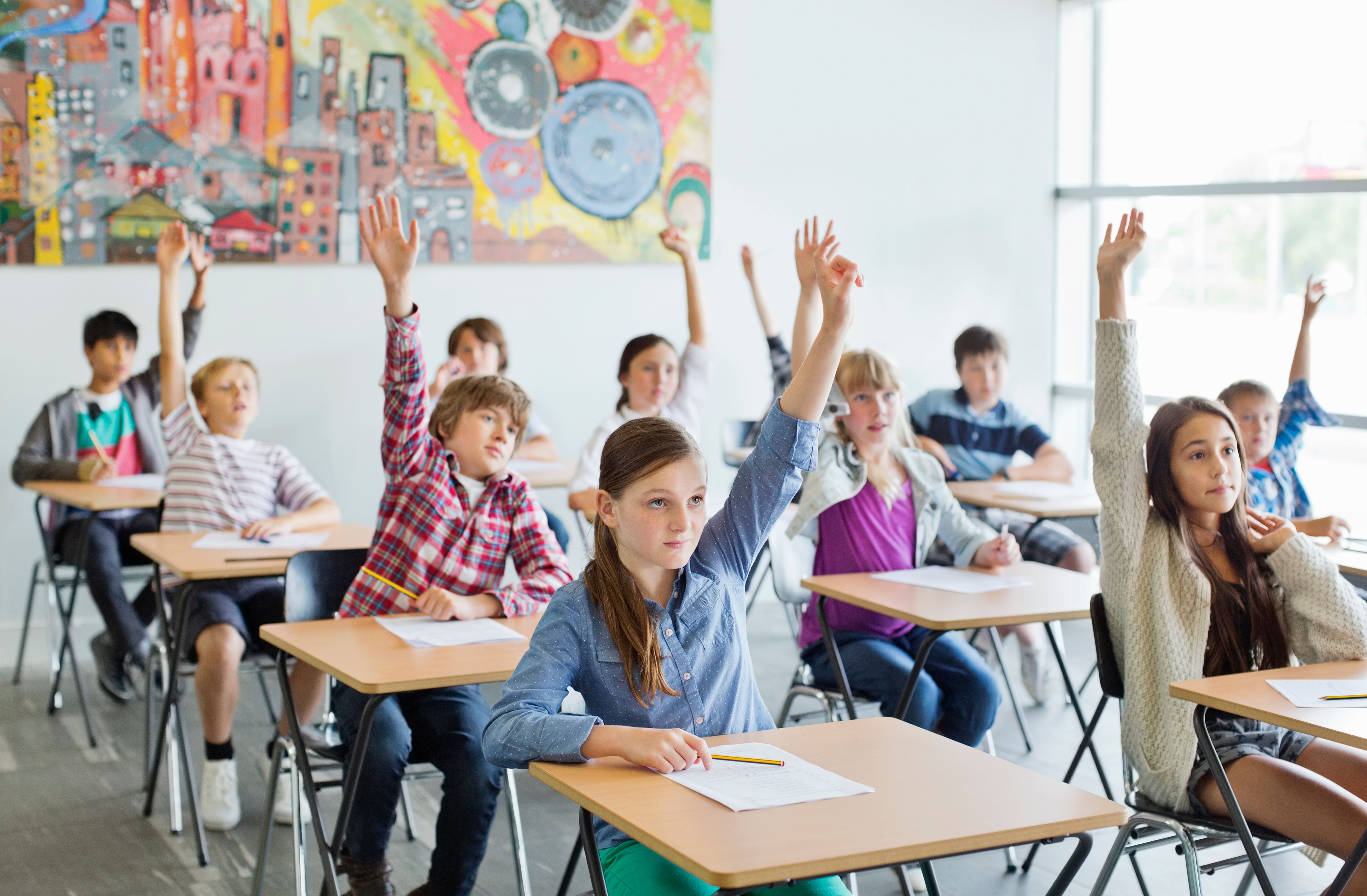Students raising their hands in class. | Source: Getty Images