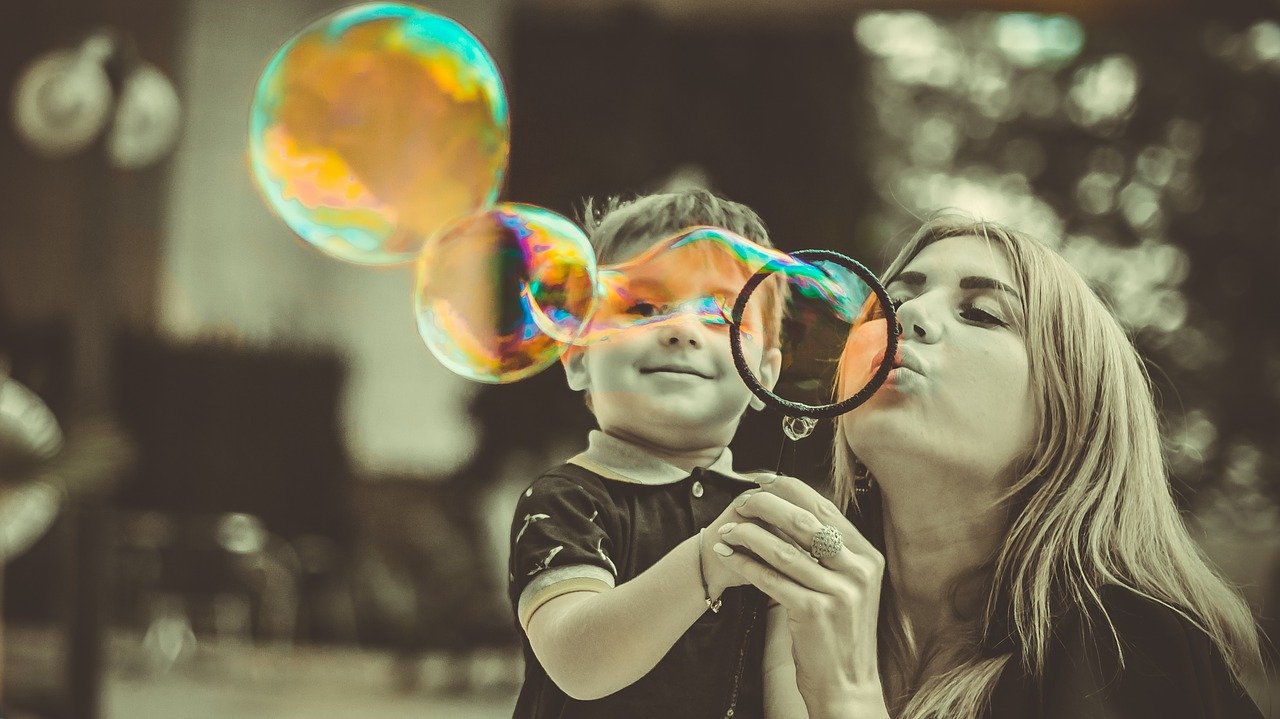 Madre soplando una burbuja con su hijo. | Foto: Pixabay