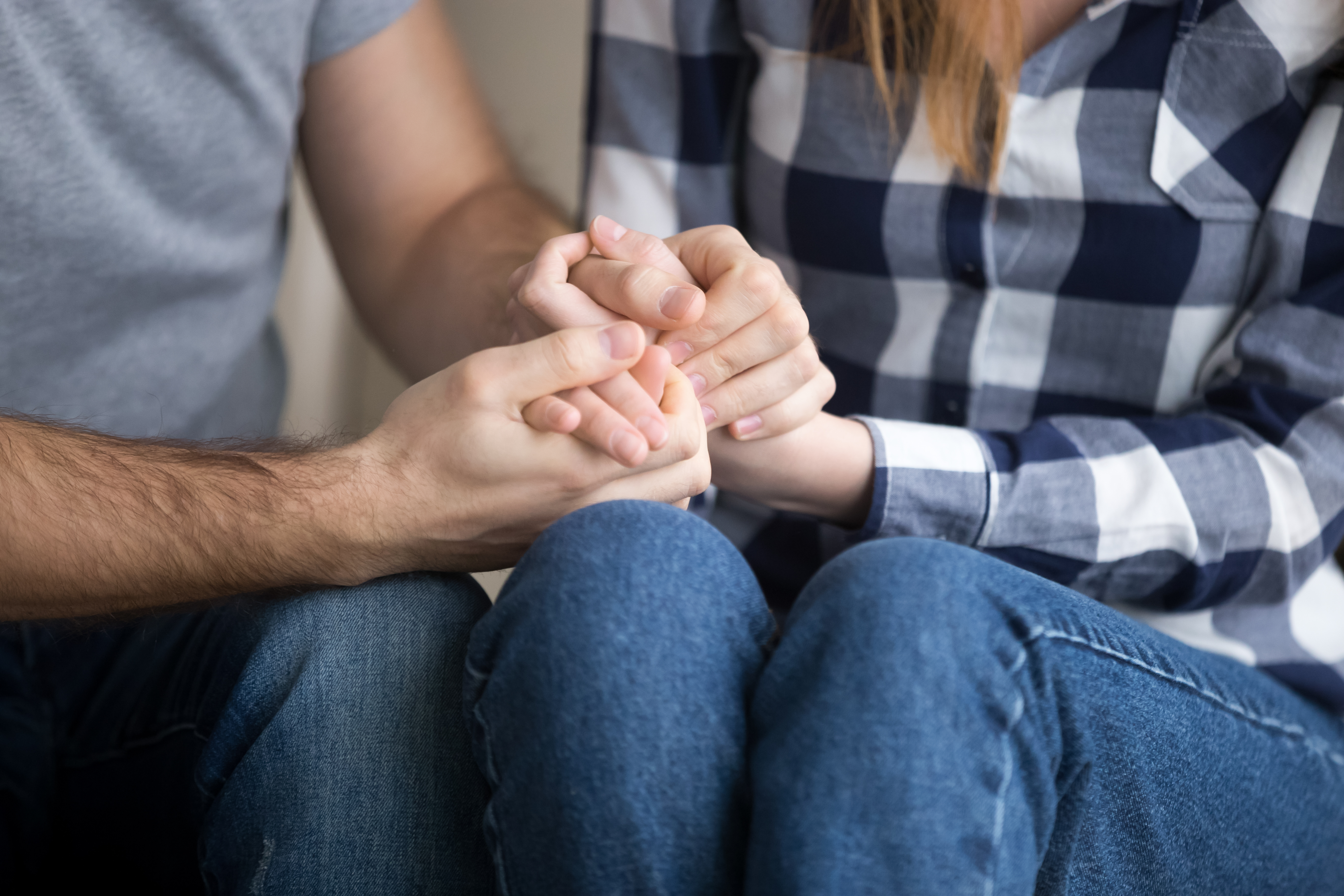 Married couple holding hands giving psychological support, close up view | Source: Getty Images