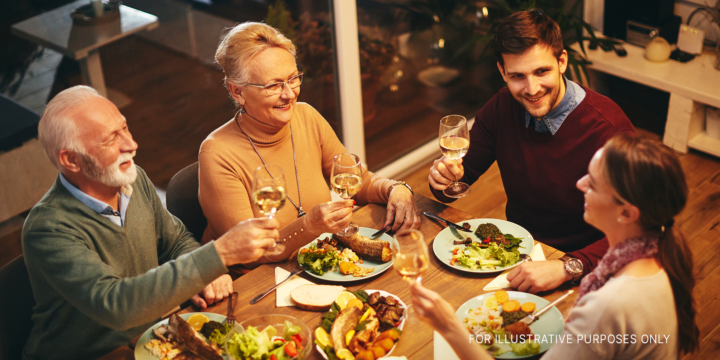 A happy family sharing a toast over dinner | Source: Shutterstock