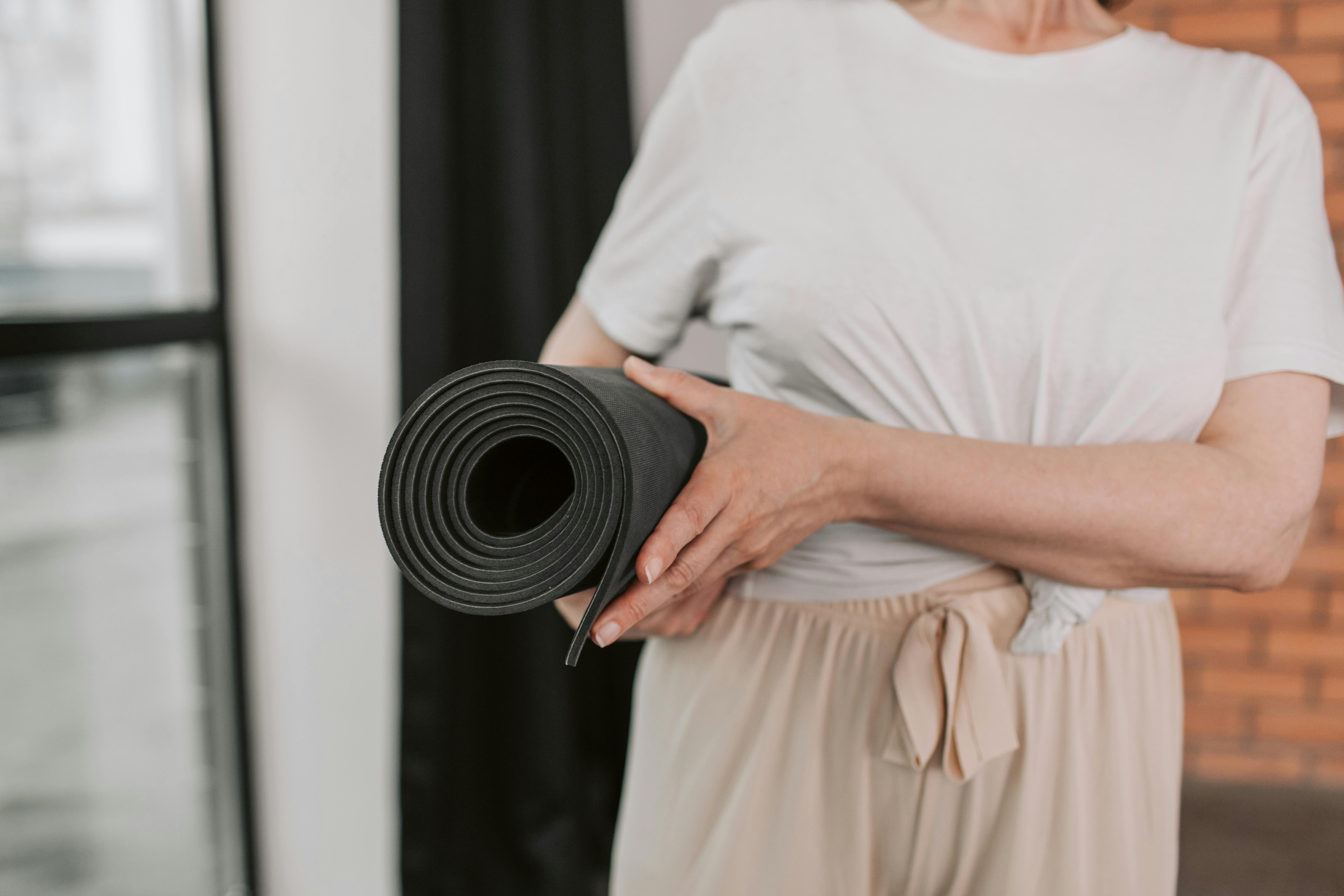 A woman carrying a yoga mat | Source: Pexels