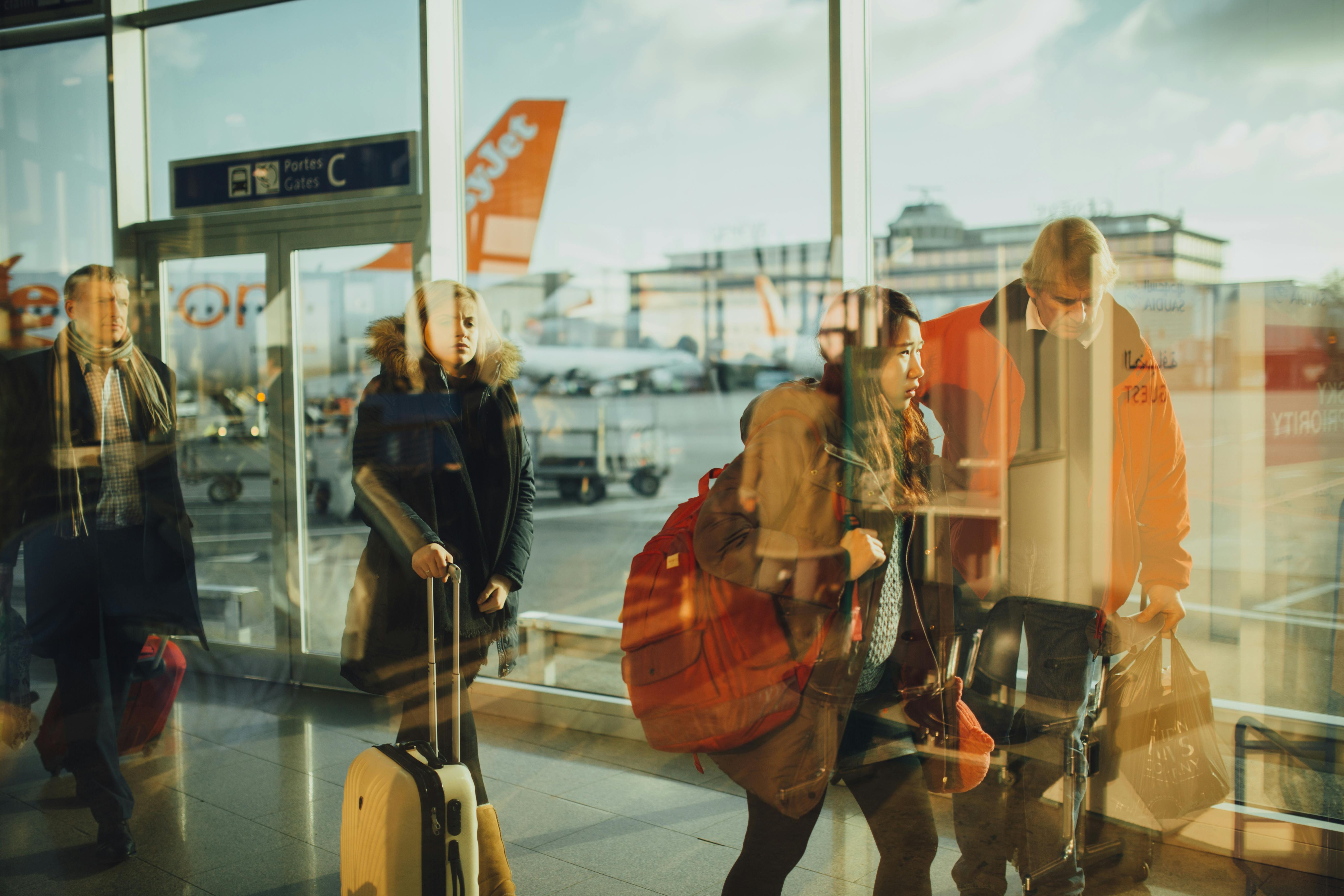 Travellers making their way through an airport concourse | Source: Pexels