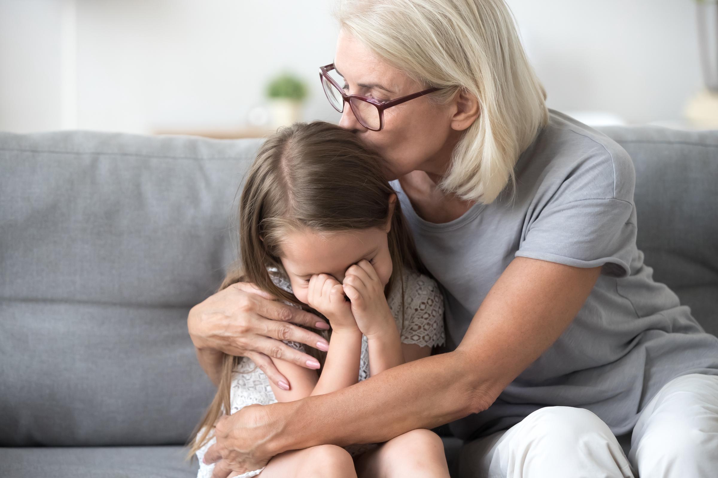 Older woman comforting a crying child | Source: Shutterstock
