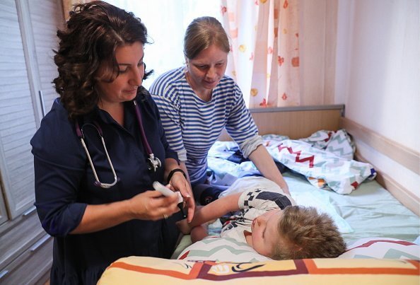 Una doctora y su asistente cuidando a un niño pequeño. | Imagen: Getty Images