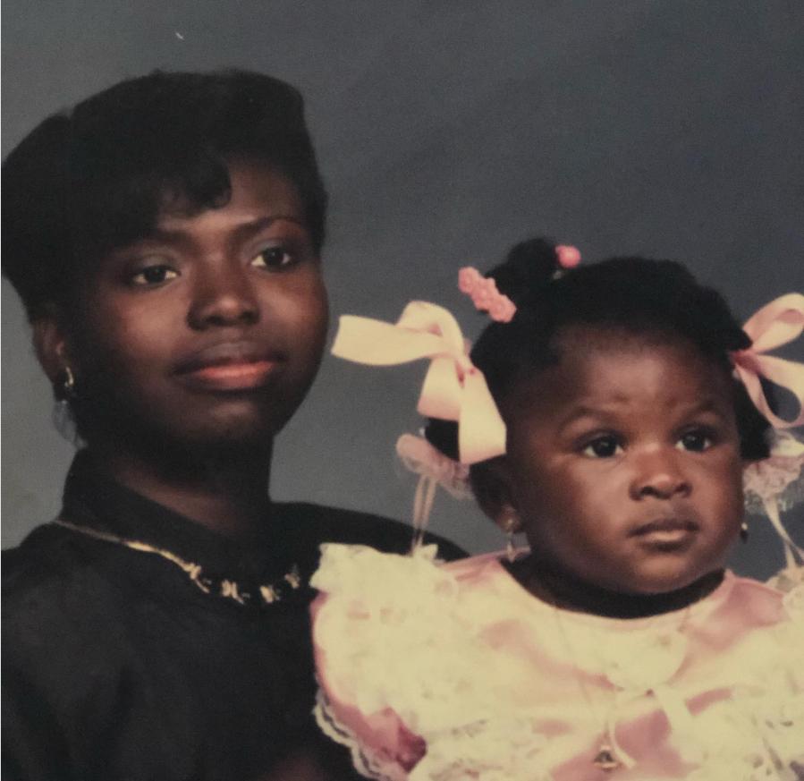 In a softly faded portrait, Nancy Metayer Bowen is held close by her mother, dressed in delicate pink with ribboned bows, her gaze quietly curious. | Source: Instagram/nancymetayerbowen