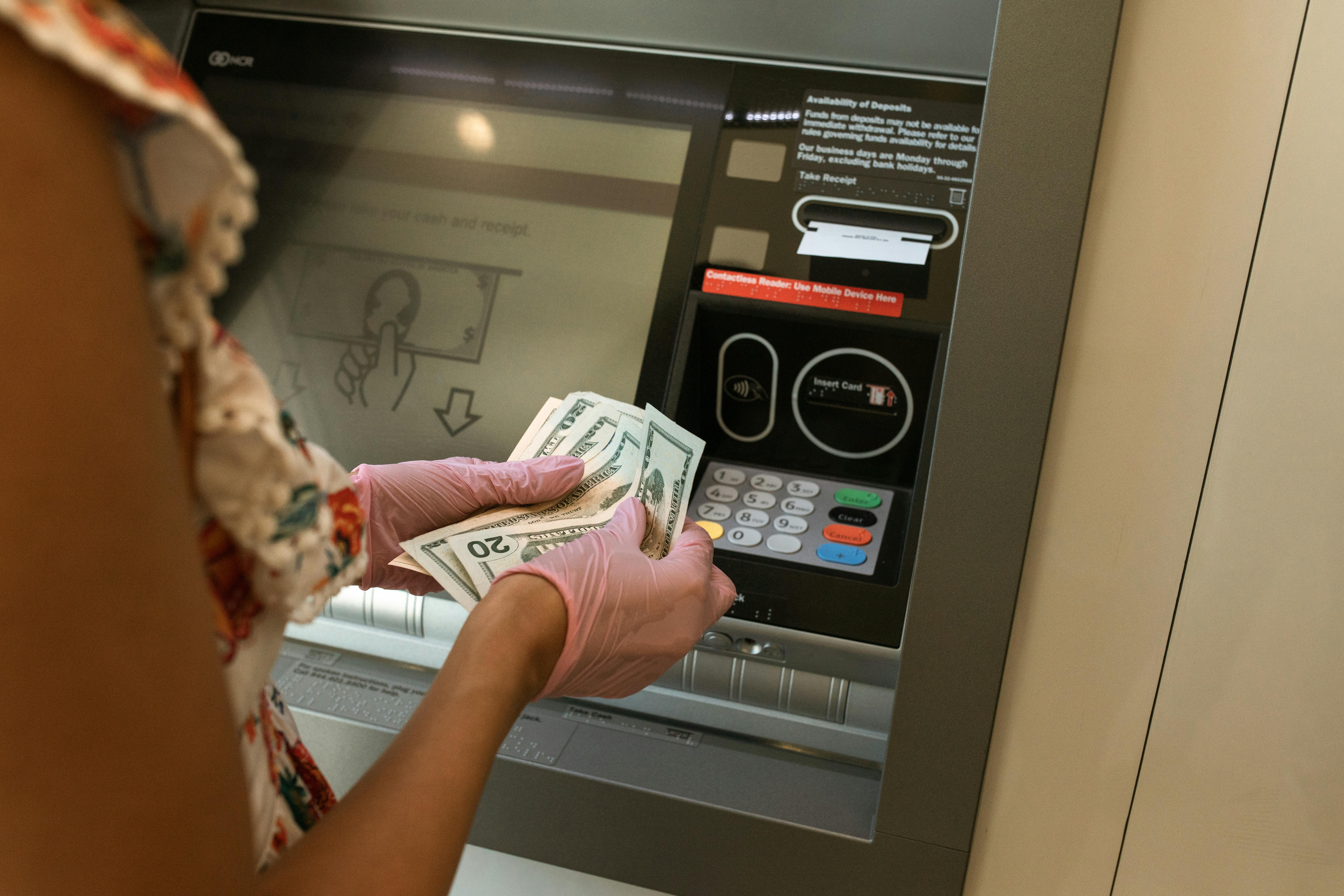 Person Counting Money in front of ATM | Source: Pexels