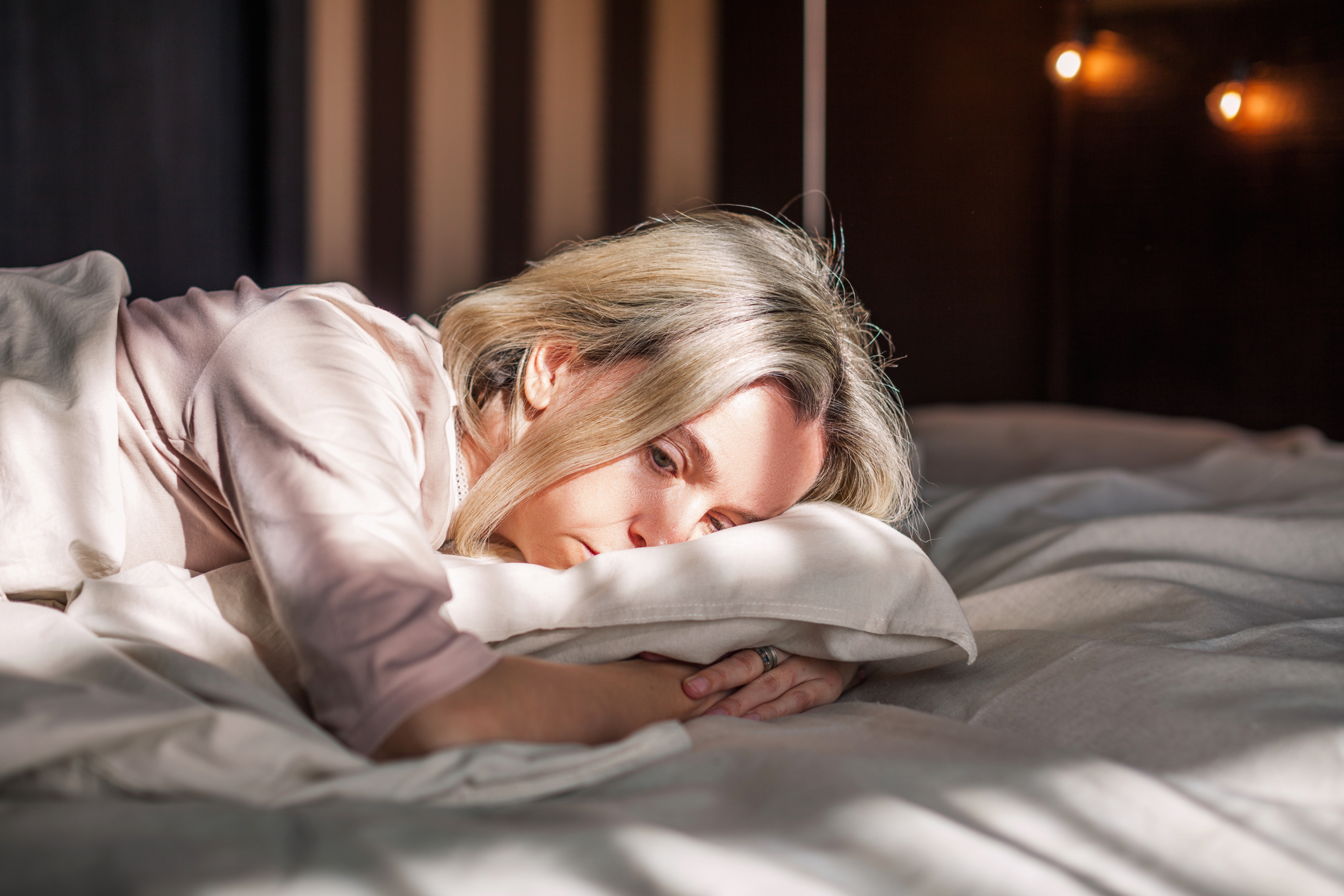 Eine depressive Frau hat Probleme beim Einschlafen und liegt hellwach in ihrem Bett | Quelle: Shutterstock