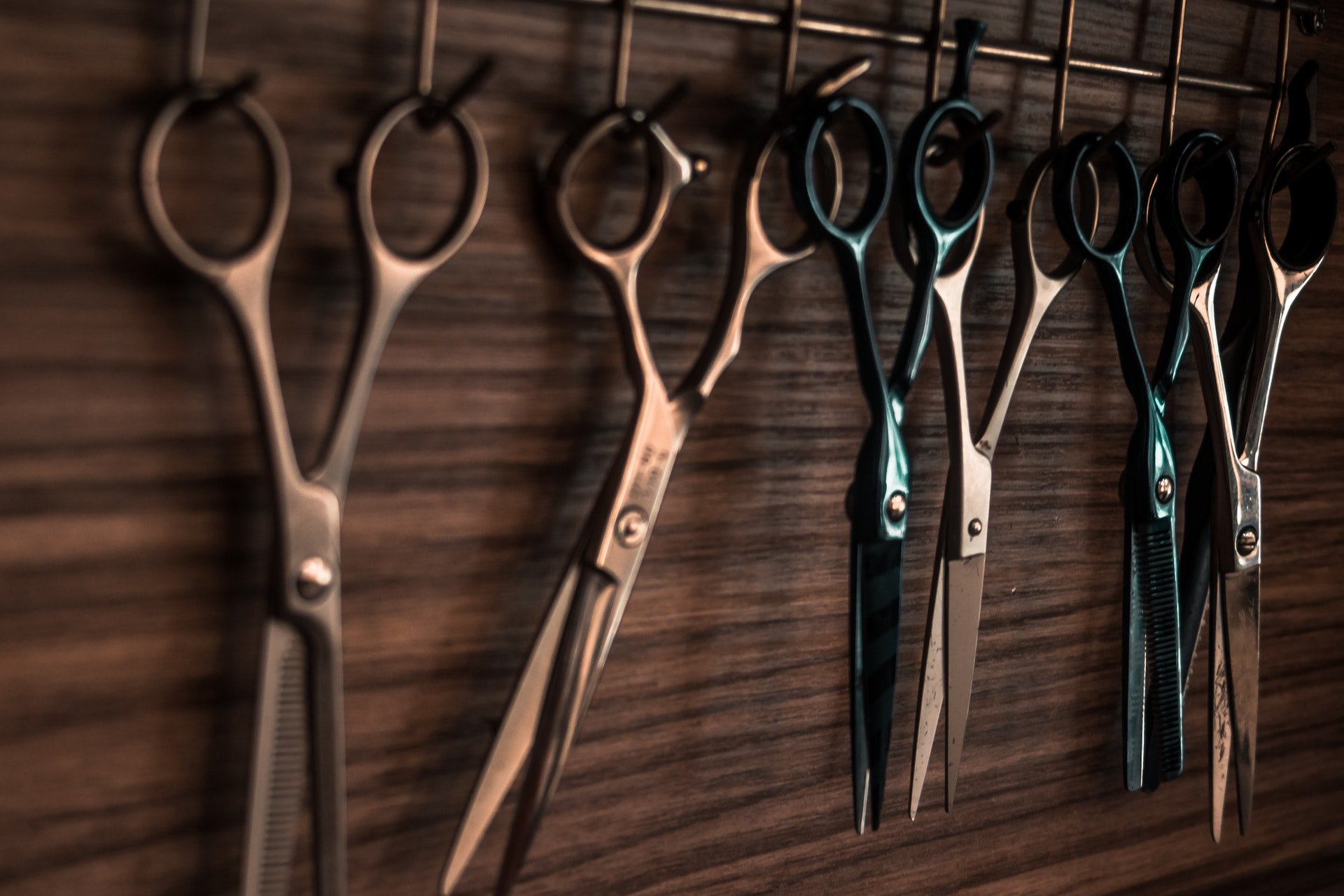 Photo of different types of scissors hanging on the wall | Photo: Pexels
