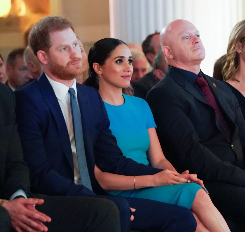 Prince Harry and Meghan Markle hold hands while sitting next to Ross Kemp during an appearance at the Endeavour Fund Awards at Mansion House on March 5, 2020, in London, England | Source: Paul Edwards - WPA Pool/Getty Images
