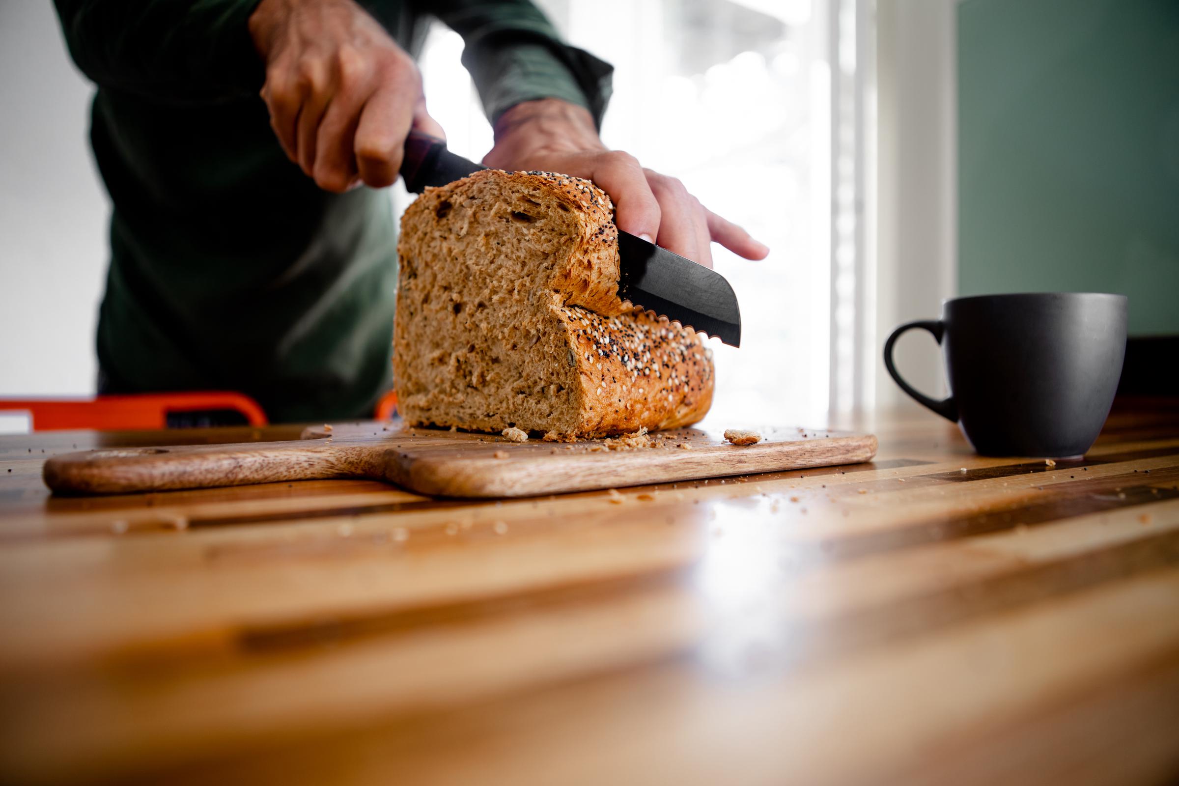 A man cutting a loaf of bread into slices | Source: Getty Images