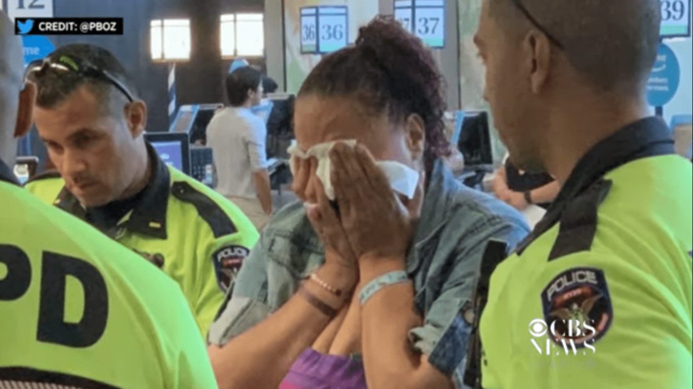 The woman in tears as officers paid for the food she stole. | Photo: Youtube.com/CBS News