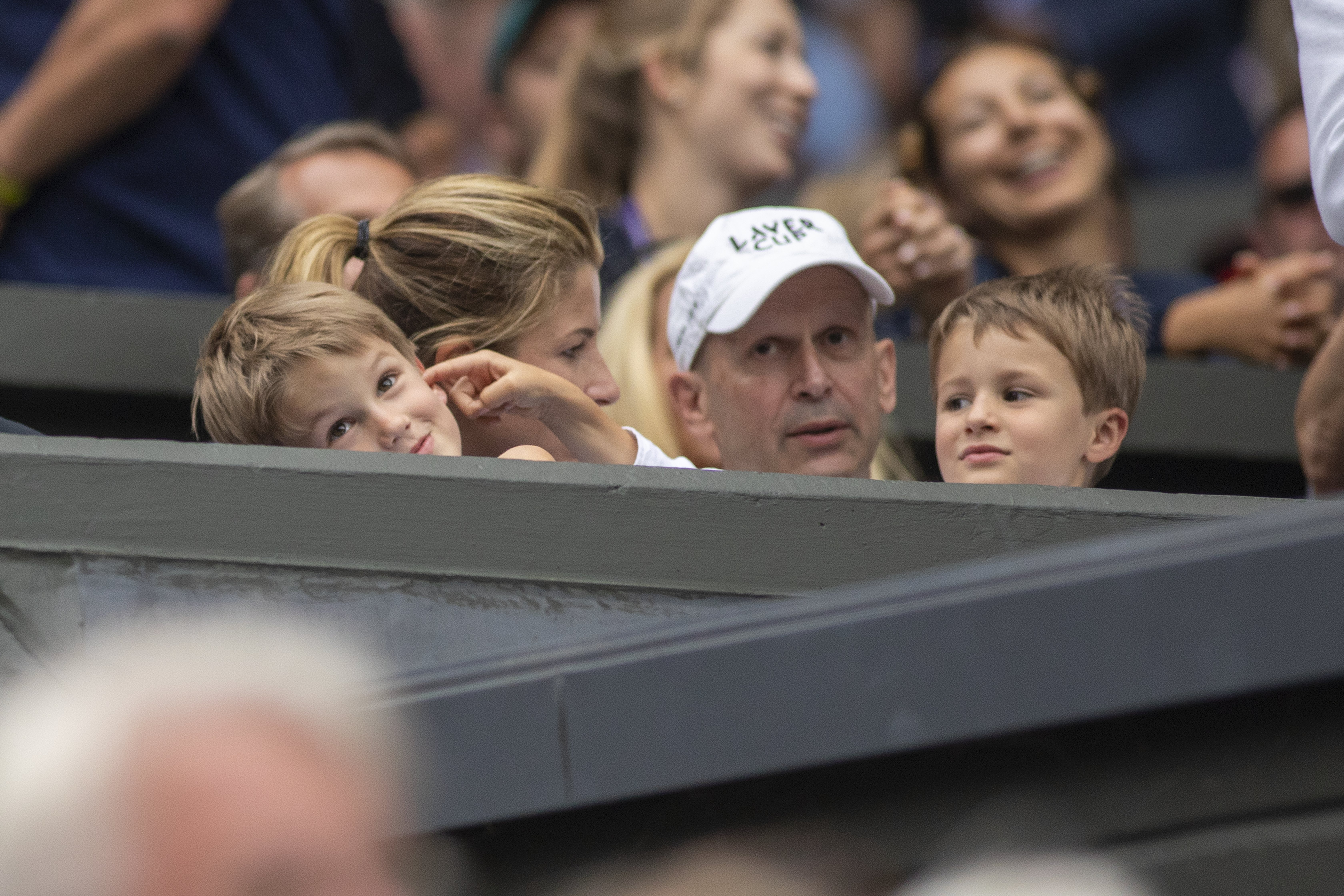 Lennert "Lenny" Federer playfully pokes his brother Leo's face as they sit on the sidelines with their mother, Mirka Federer, at Wimbledon on July 8, 2019, in London, England.  | Source: Getty Images