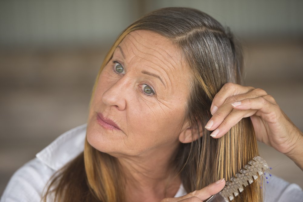 Mujer con melena larga cepillando su cabello. | Foto: Shutterstock