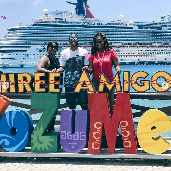 Alysha Burney with her brother Charles Burney and another loved one posing for a photo in front of a cruise ship, posted on July 26, 2018. | Source: Instagram/charles_burney