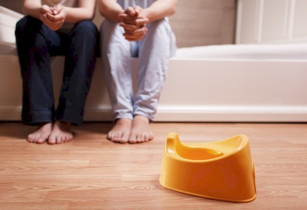 Mom and dad in front of a potty seat | Source: Freepik