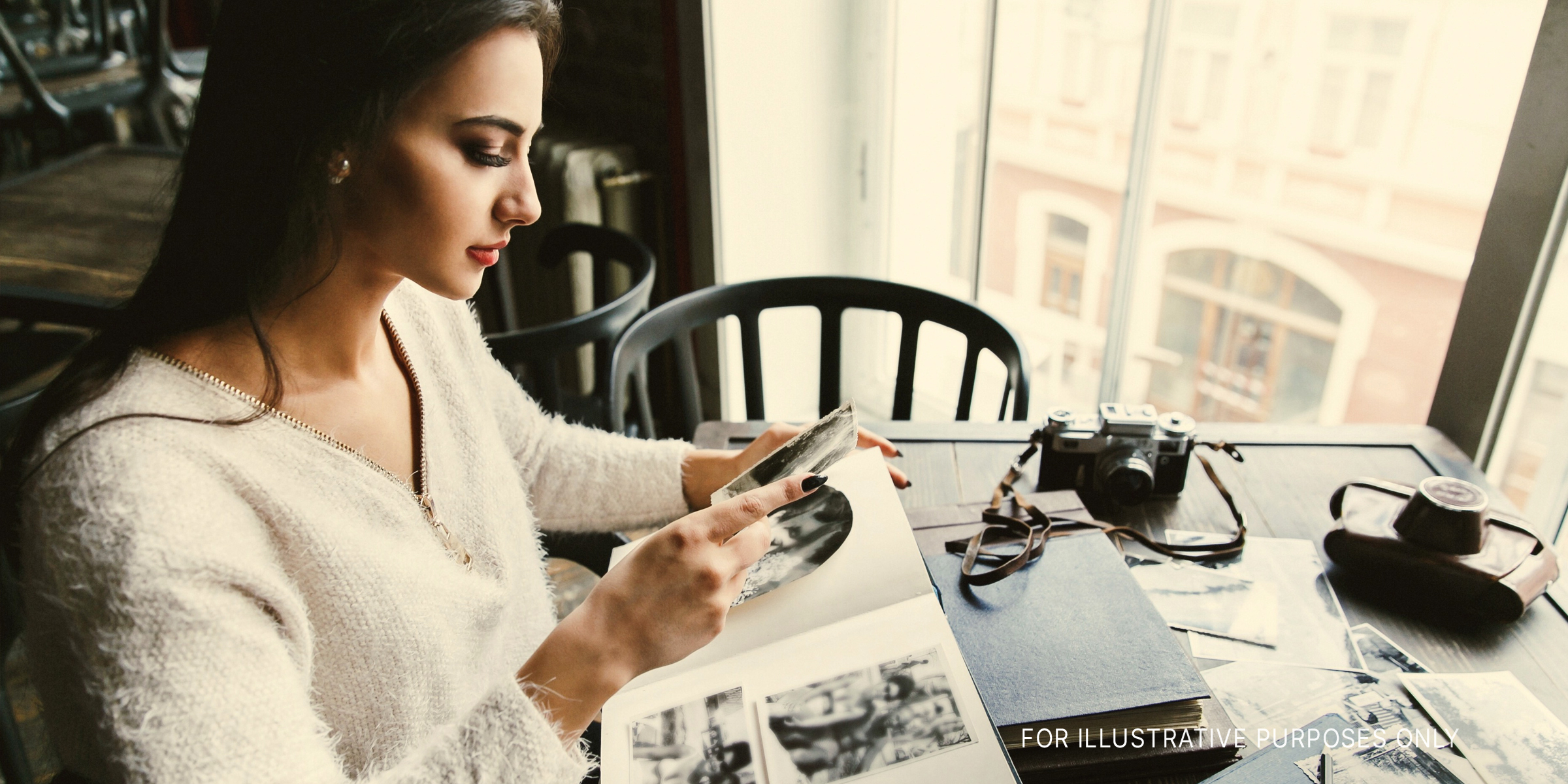 A woman looking through a scrapbook | Source: Shutterstock