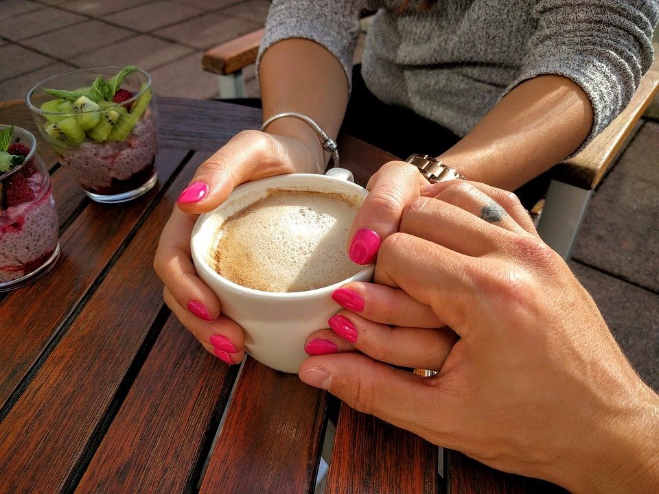 Hands coming together during a coffee date. | Source: Pixabay