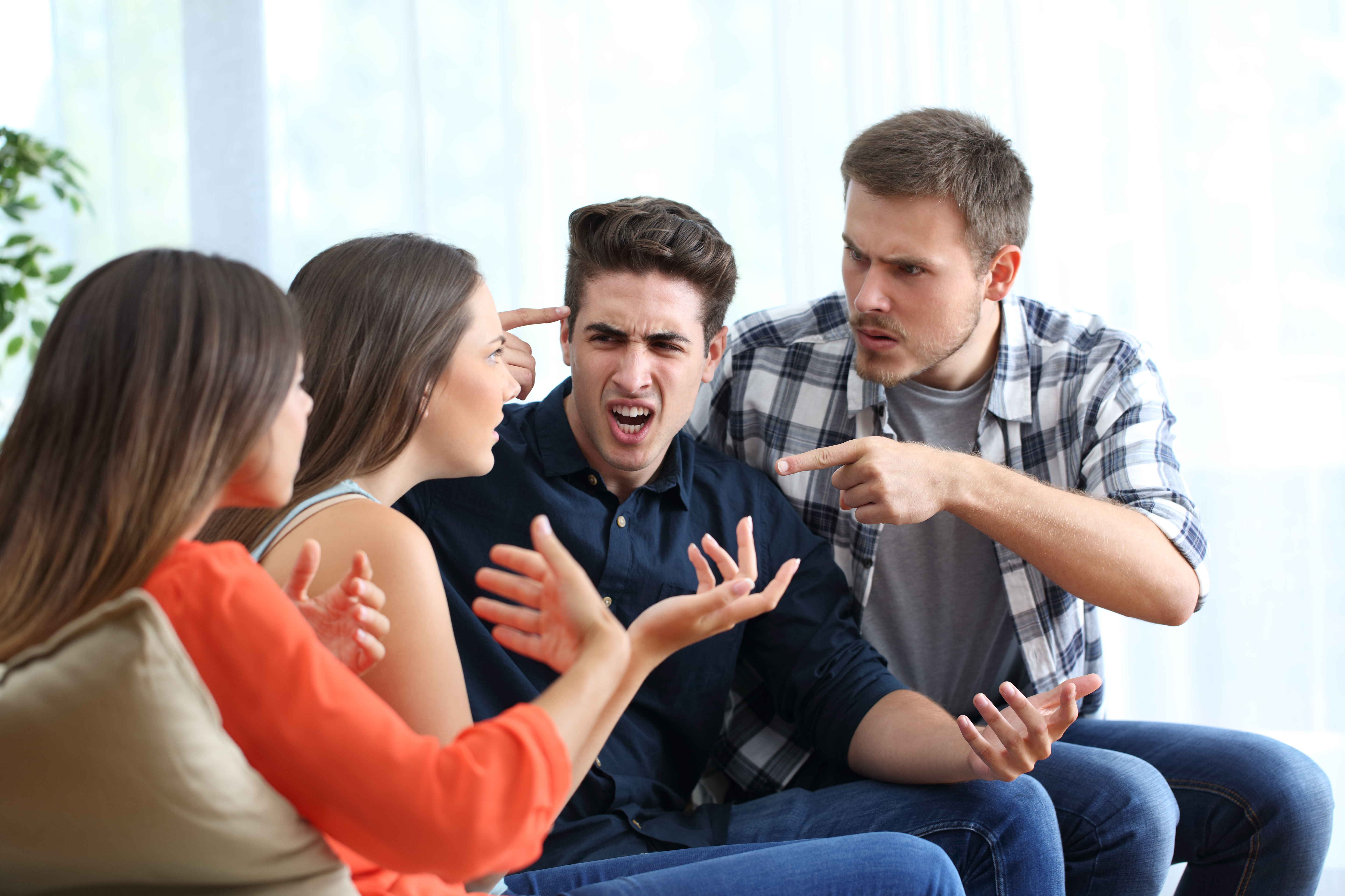 Four angry friends arguing at home | Source: Getty Images