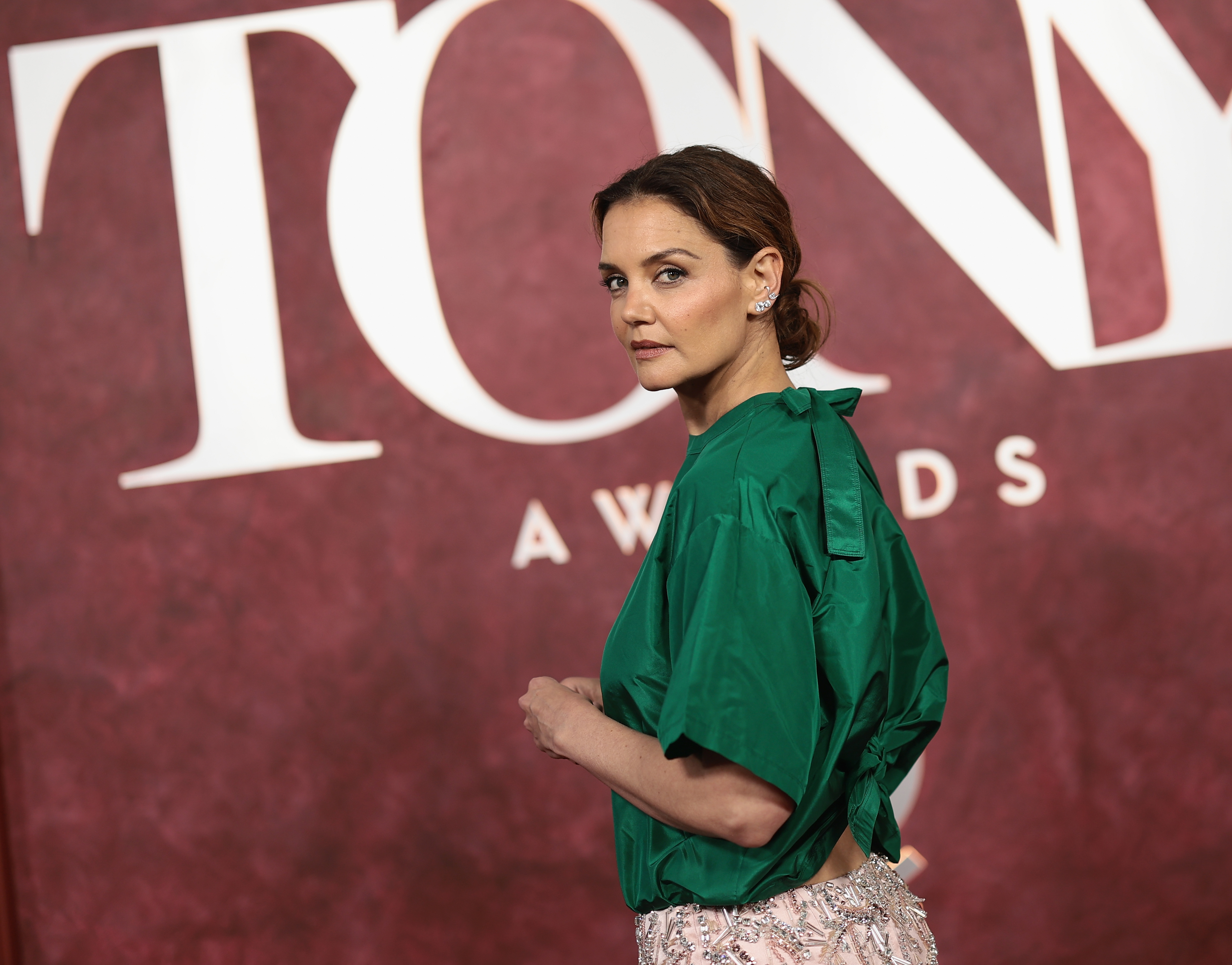 The actress turns heads in a vibrant emerald green top and a pale pink beaded skirt, opting for a minimalist yet standout look that drew attention against the deep red backdrop of the occasion.