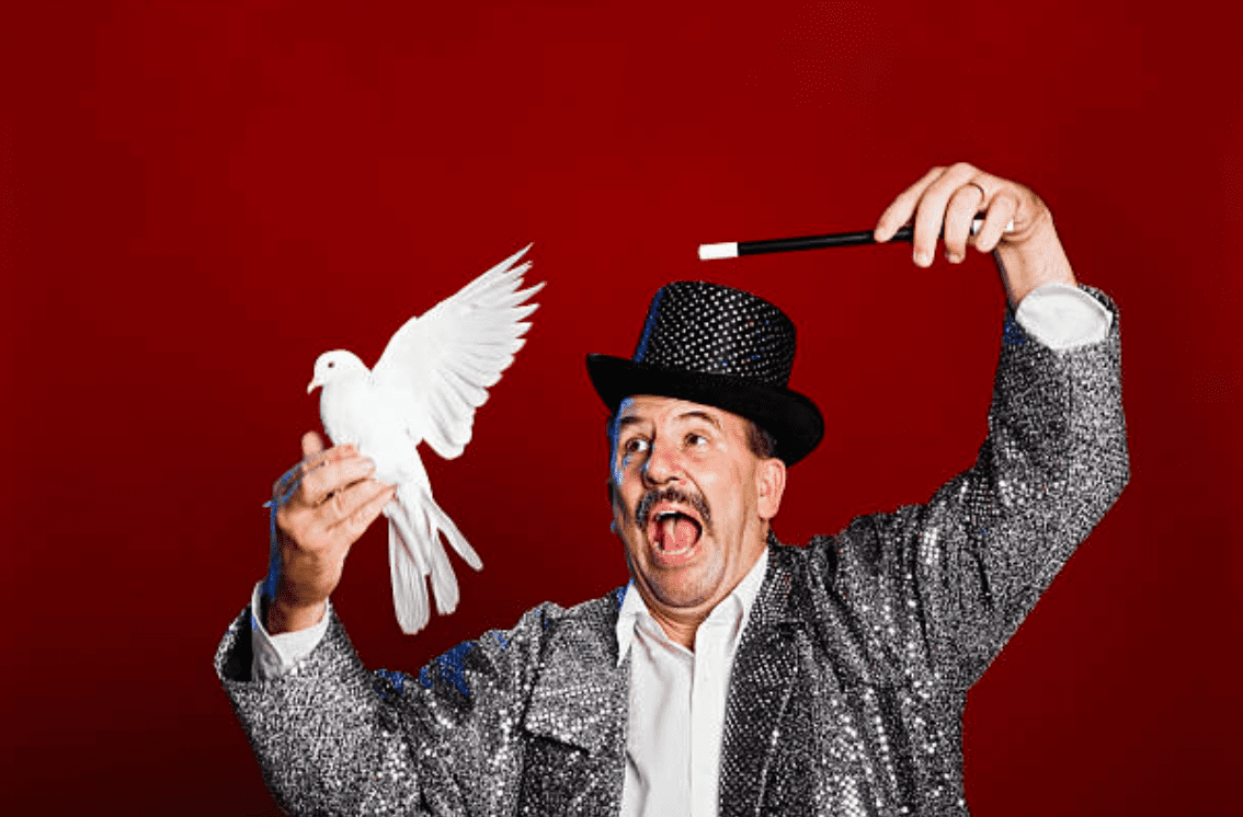 Magician holding a white dove and wand in his hand | Source: Getty Images