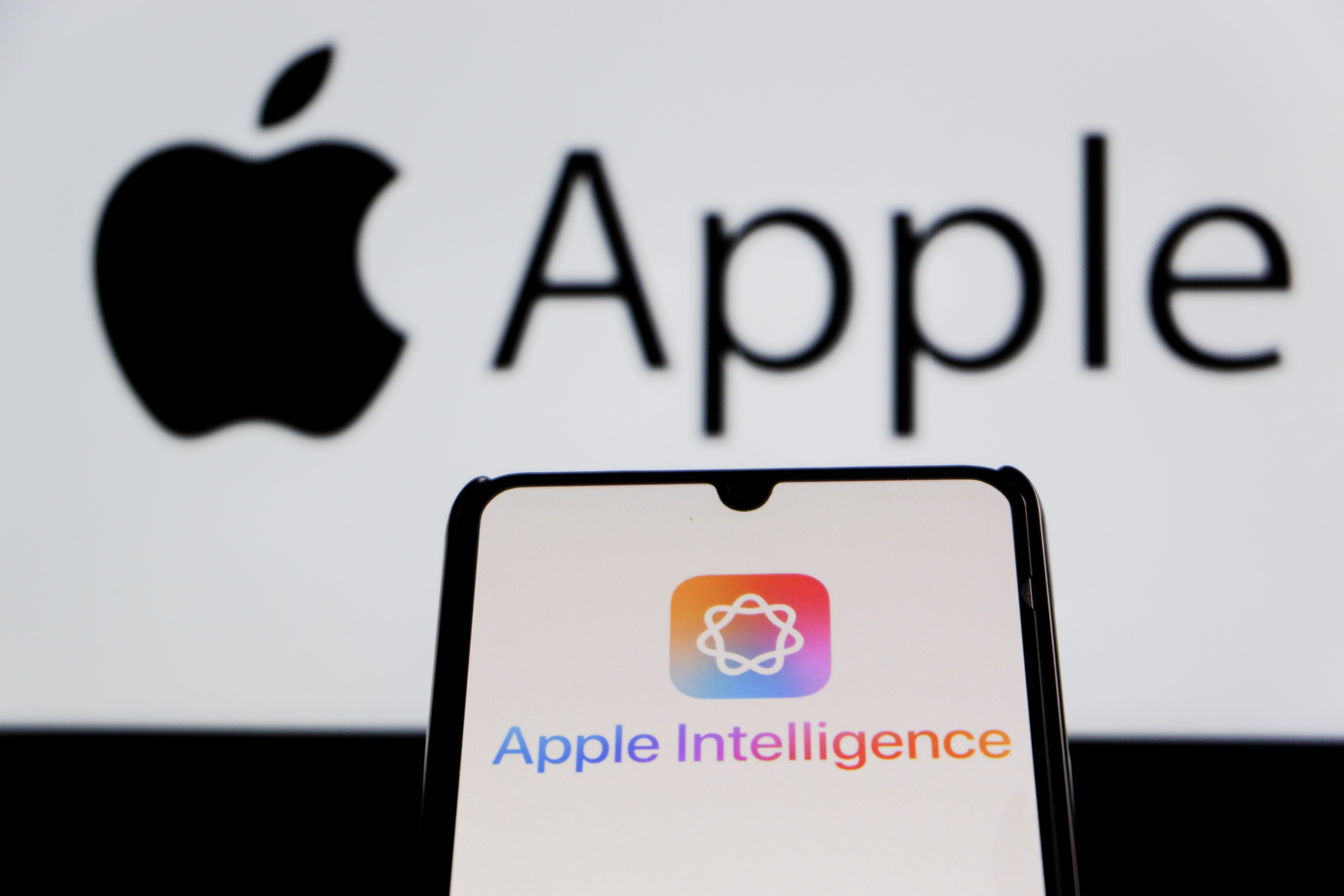 The Apple Intelligence logo is seen displayed on a smartphone with an Apple logo in the background in Indonesia in 2025 | Source: Getty Images