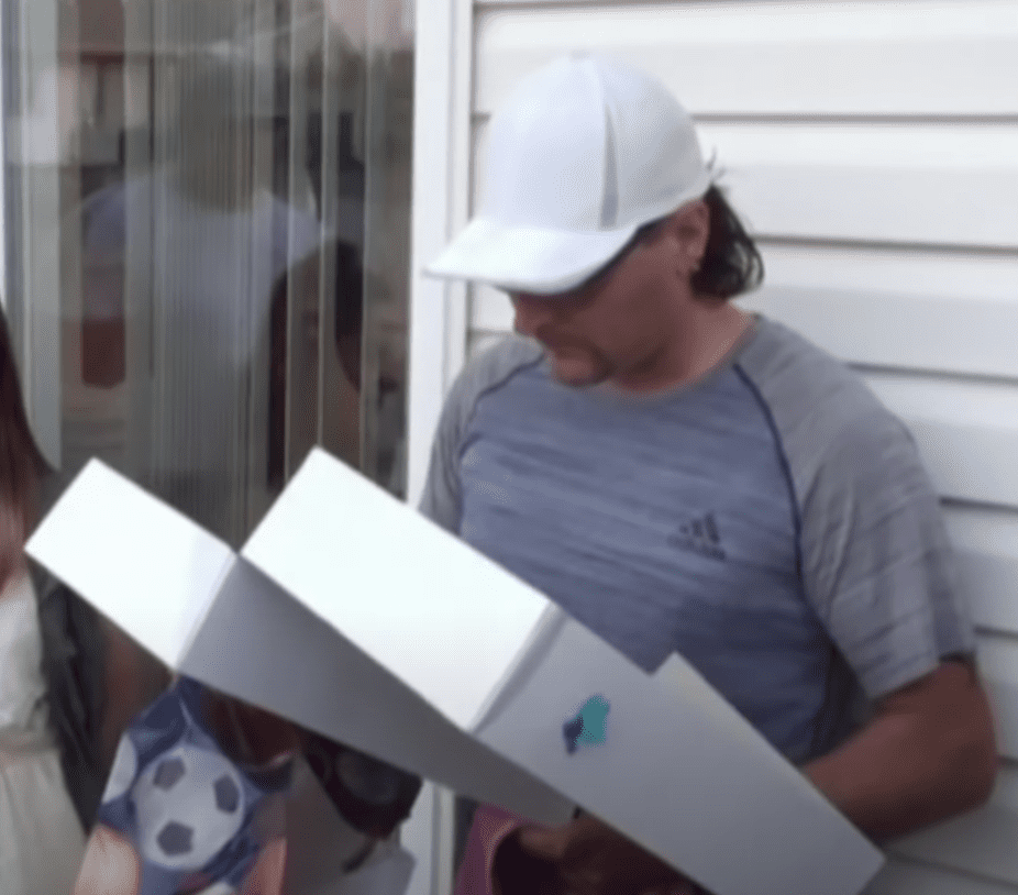 Man opens a gift box and is overcome with emotion after he sees what is inside | Photo: Youtube/CBS Chicago