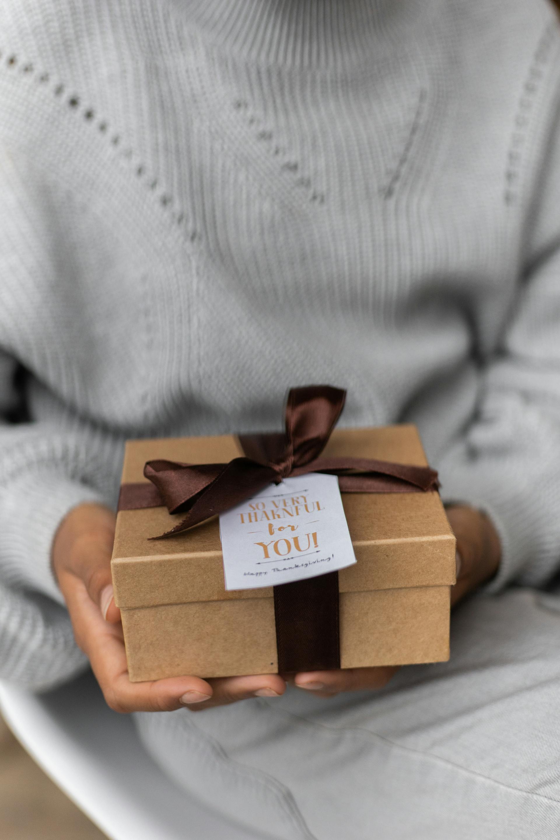 A closeup of a woman holding a small gift box | Source: Pexels