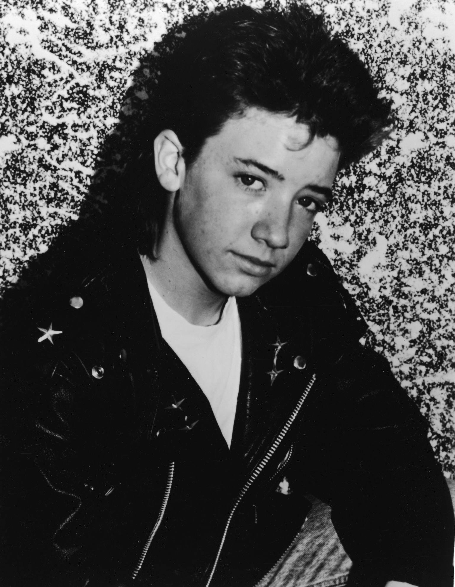 actor David Faustino wears a leather motorcycle jacket in a promotional portrait for the television series, "Married...With Children" | Getty Images