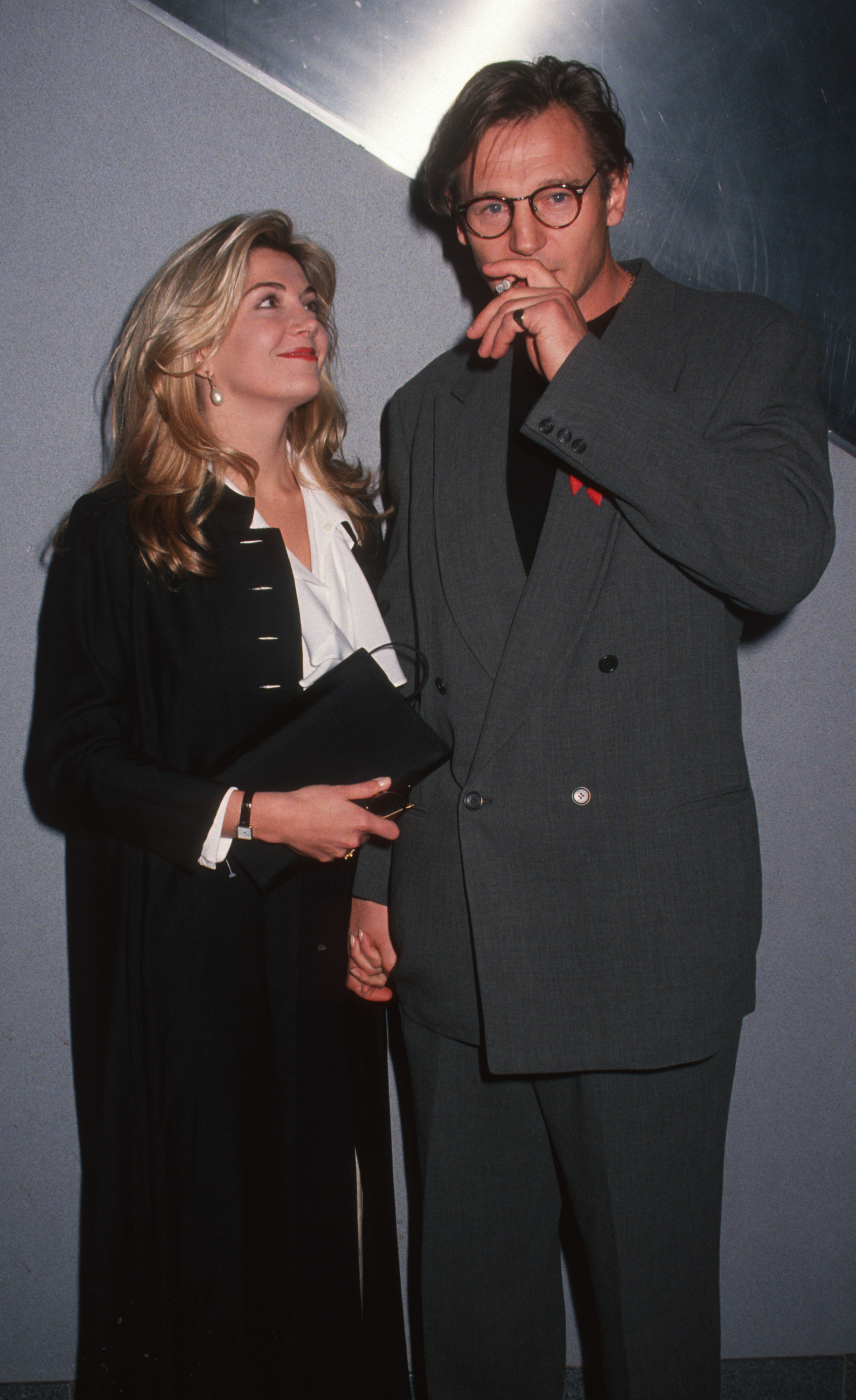 Natasha Richardson and Liam Neeson attend the screening of “Schindler’s List,” standing close together as they pose for photographs. Richardson smiles warmly at Neeson while he looks toward the camera during the 1993 event.