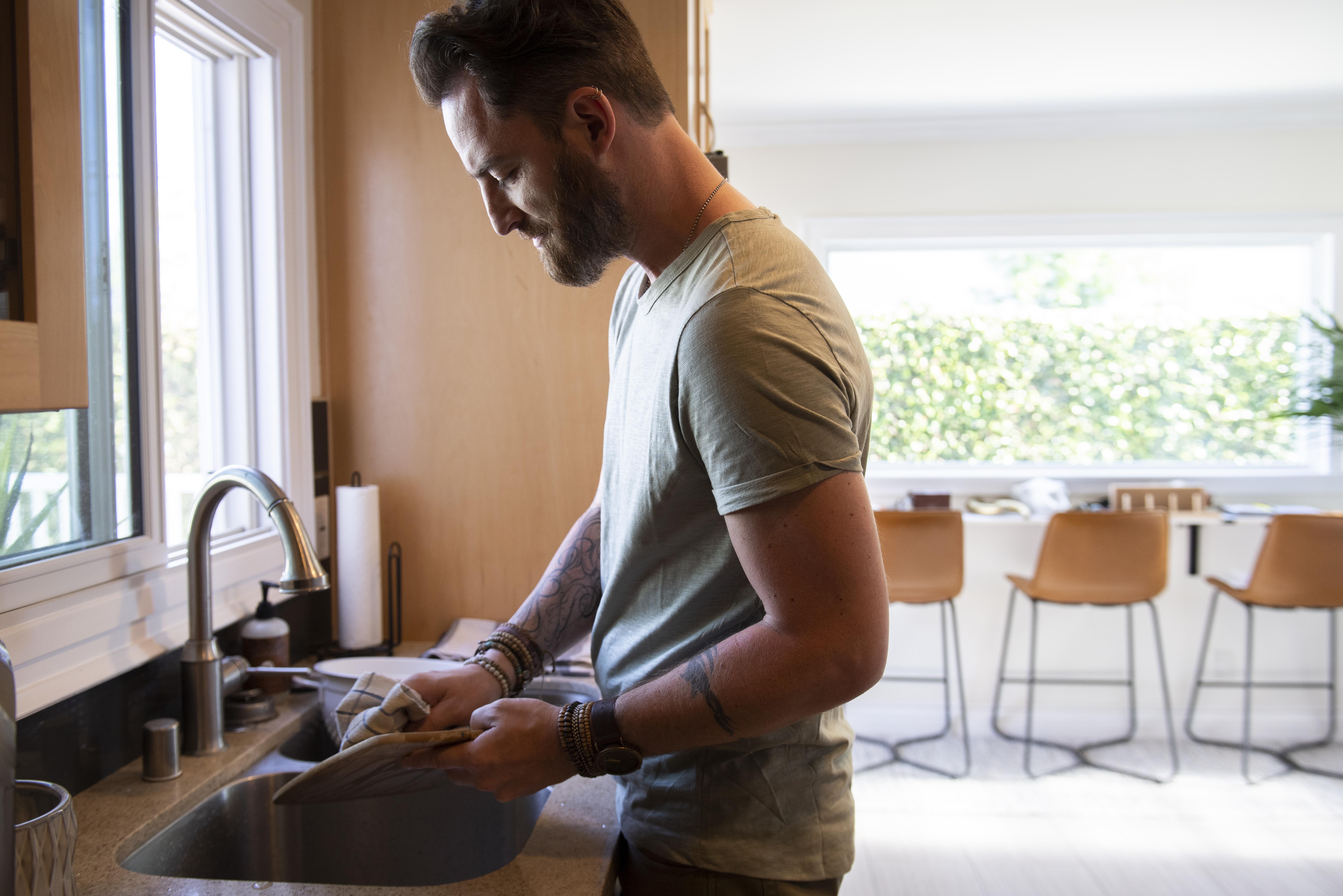 Man washing dishes in the kitchen | Source: Freepik