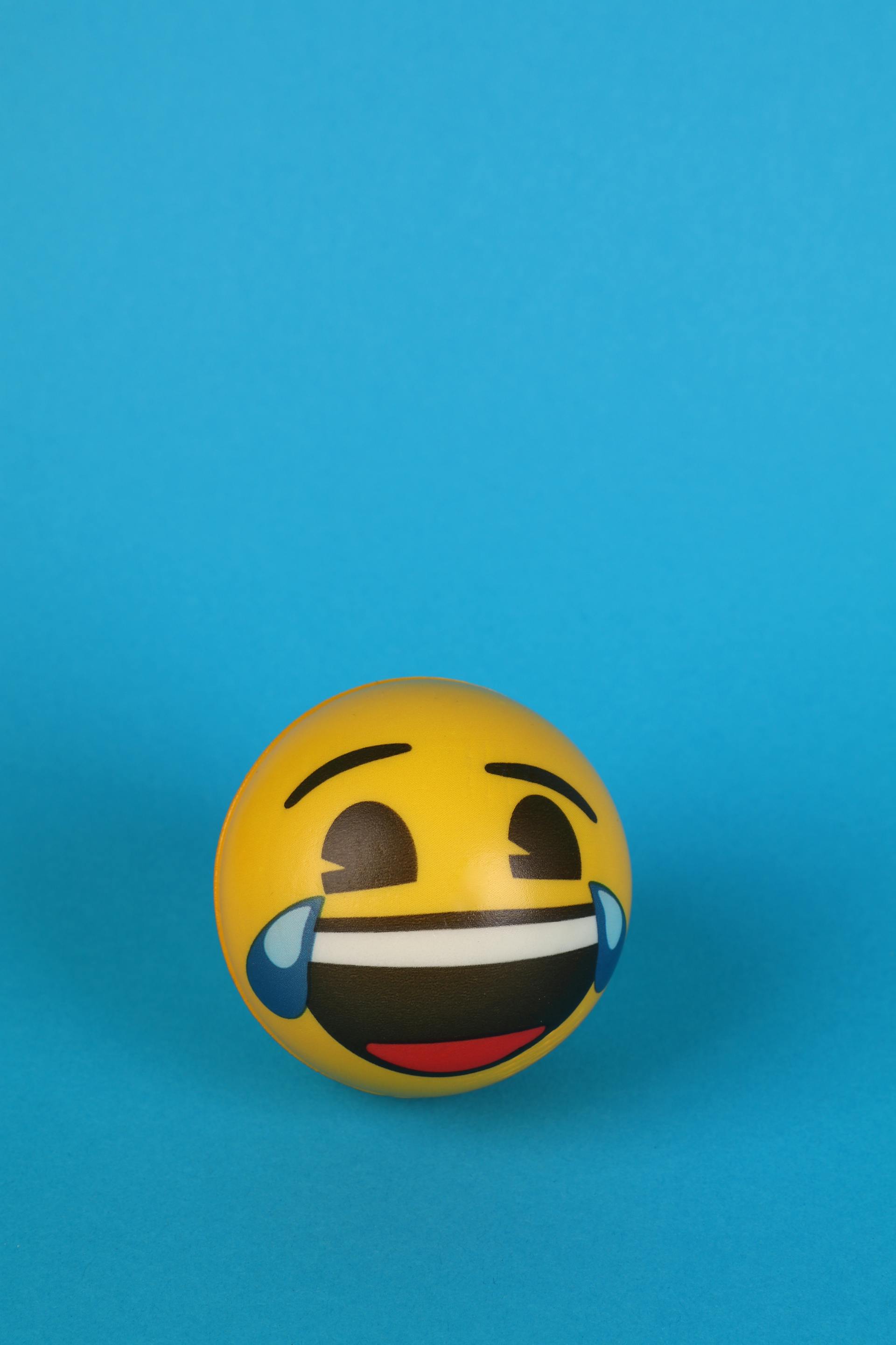 A teary-eyed laughing emoji painted on a yellow ball | Source: Pexels