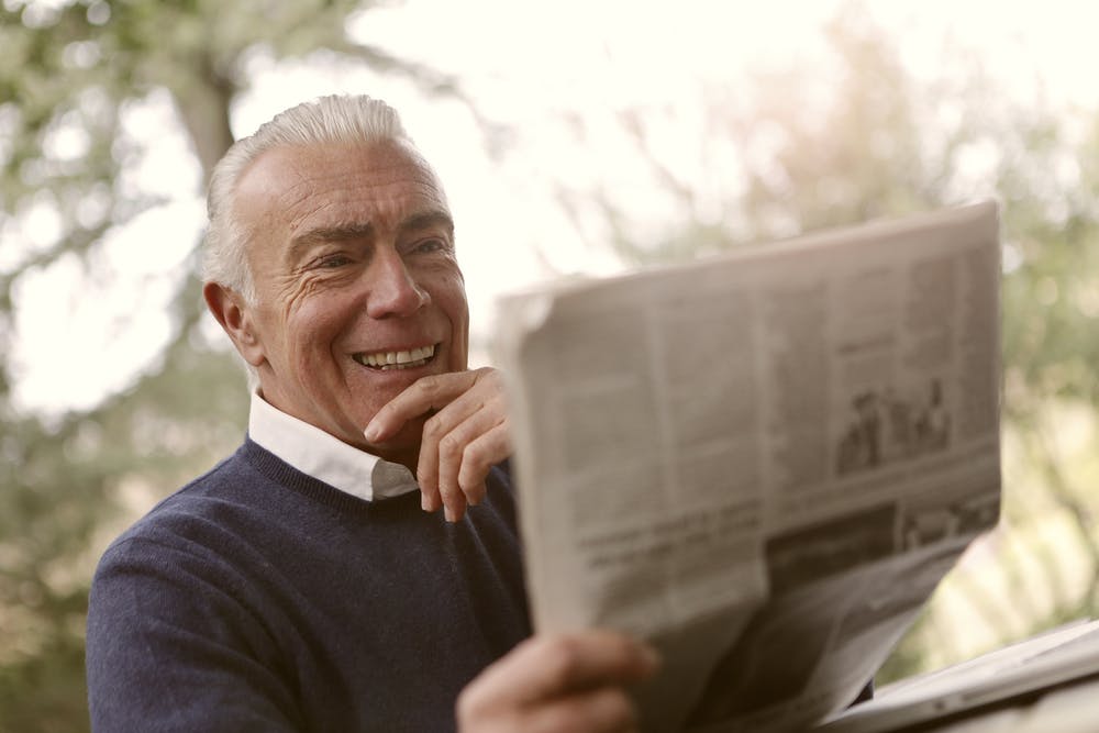 Mann beim Lesen einer Zeitung. | Quelle: Pexels