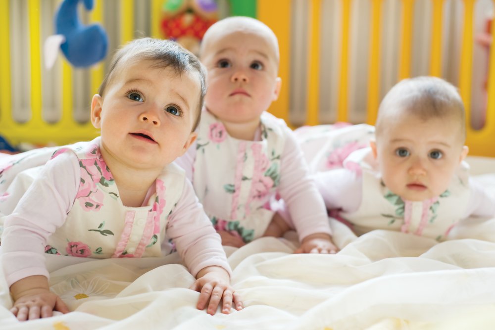 Sweet small triplets lying in nursery room. | Photo: Shutterstock