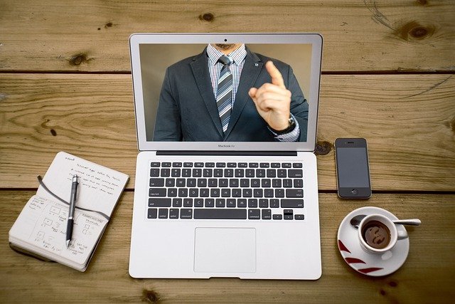 Computador sobre la mesa con una conferencia virtual en la pantalla. | Foto: Pixabay