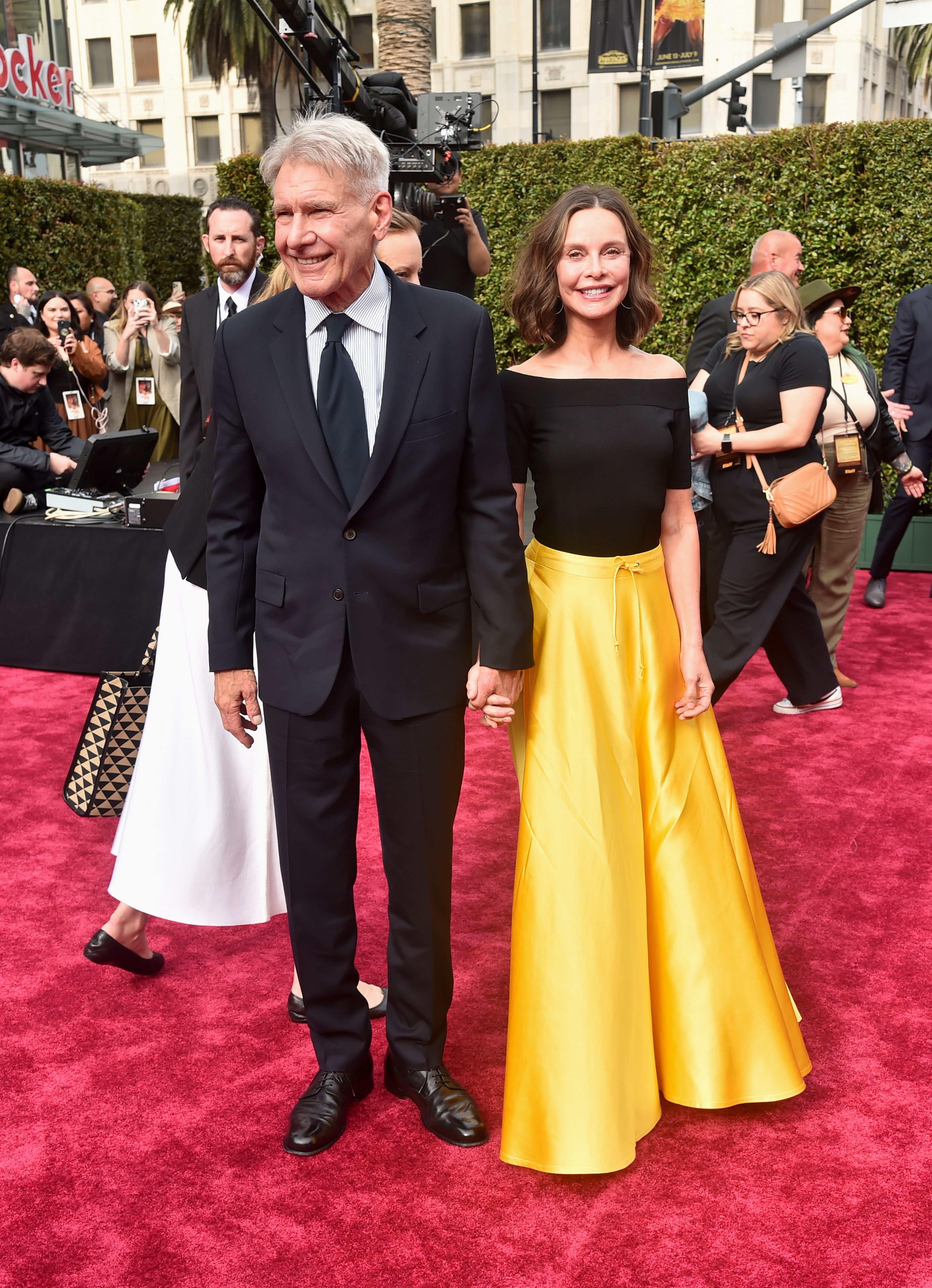 Walking the red carpet hand-in-hand with his wife, Calista Flockhart, Harrison Ford shows off a remarkably trim and upright posture at the U.S. premiere of "Indiana Jones and the Dial of Destiny." Decades after first stepping into the role of the adventurous archaeologist, the actor's lean, athletic build proves he has maintained the impressive physical conditioning of a true action star. | Source: Getty Images