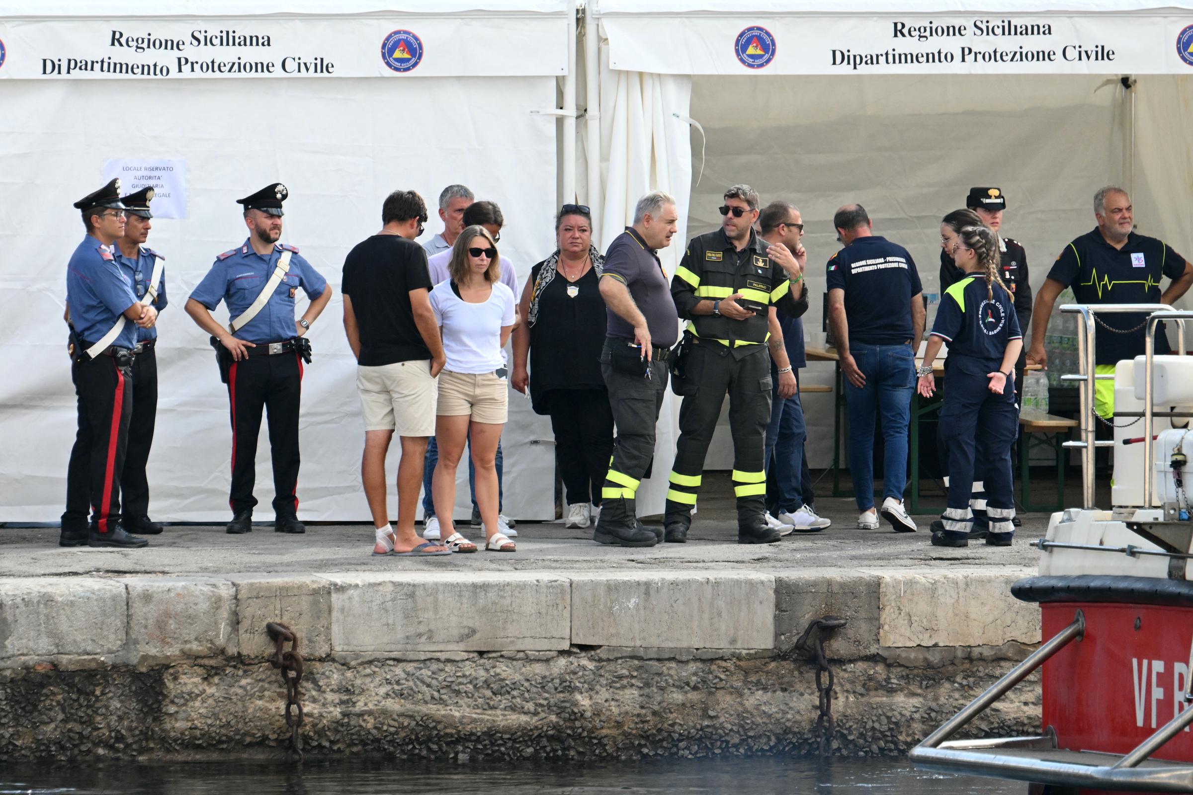 People stand with local authorities and rescuers on the pier of Porticello near Palermo on August 22, 2024 | Source: Getty Images