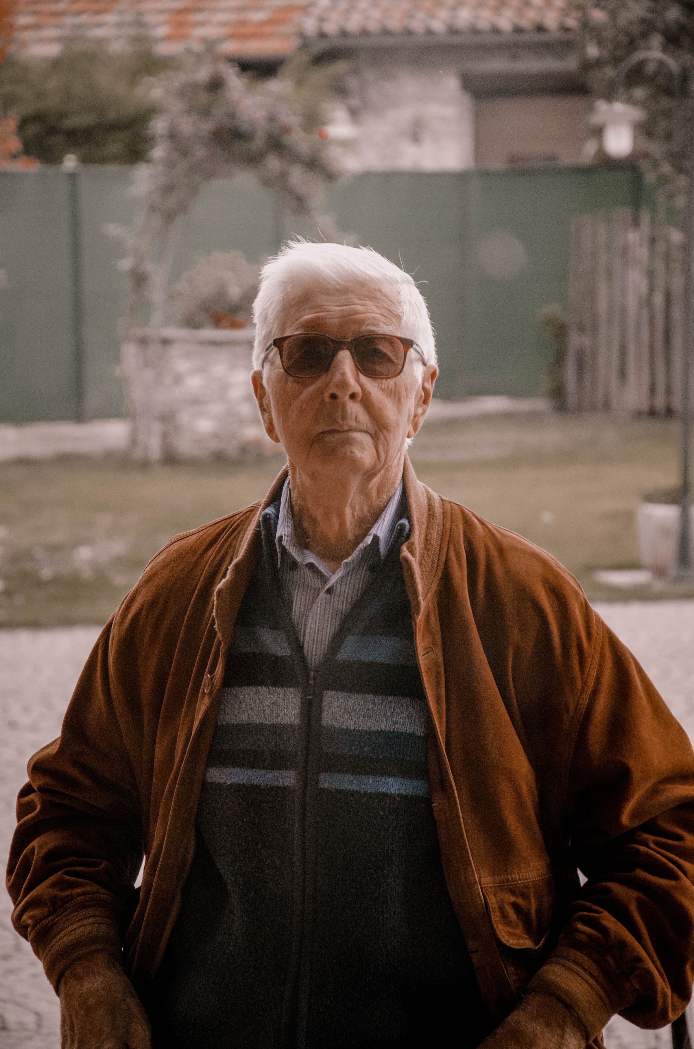 An elderly man in a brown jacket wearing sunglasses | Source: Unsplash