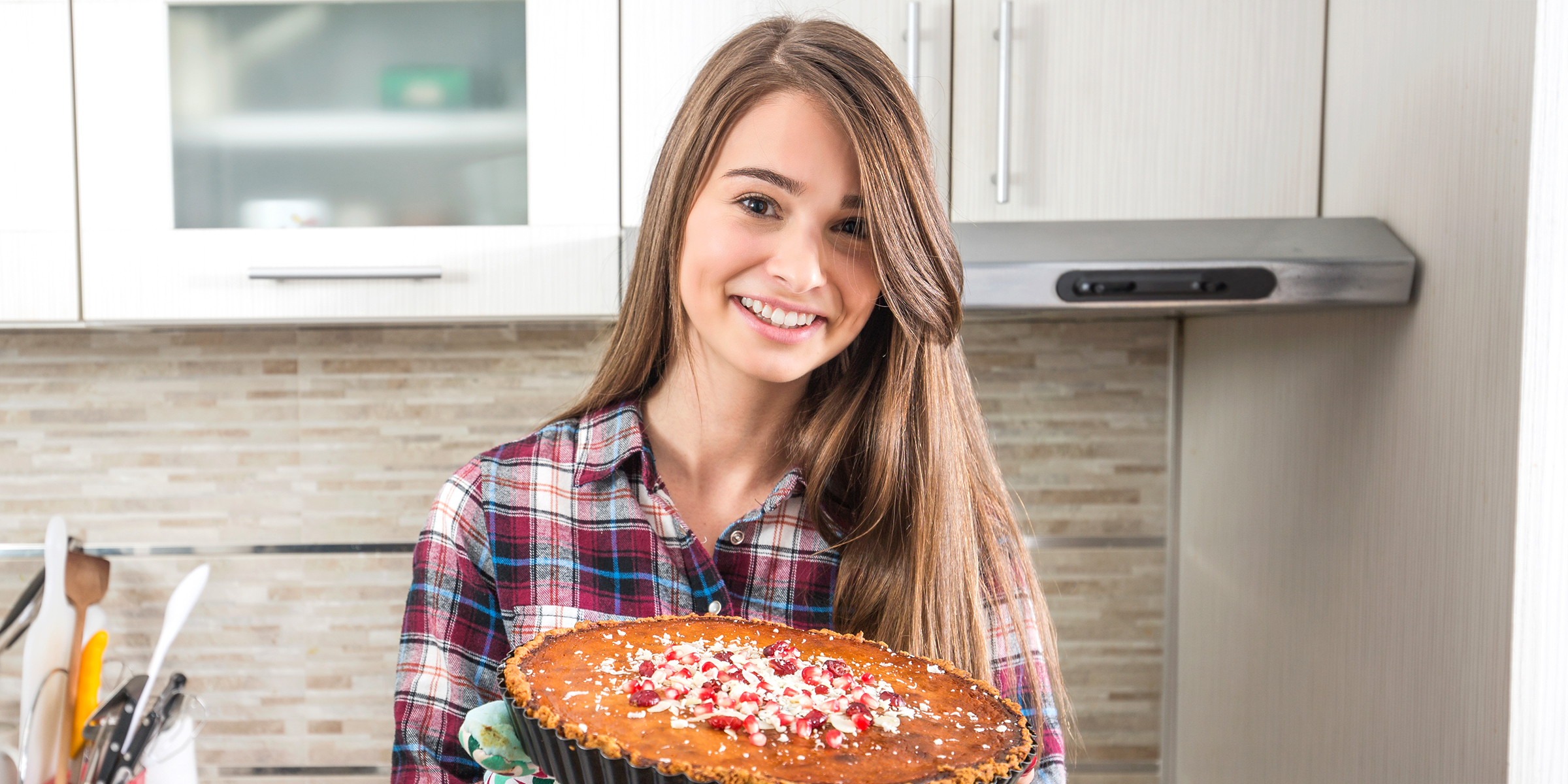 A smiling woman holding a pie | Source: Shutterstock