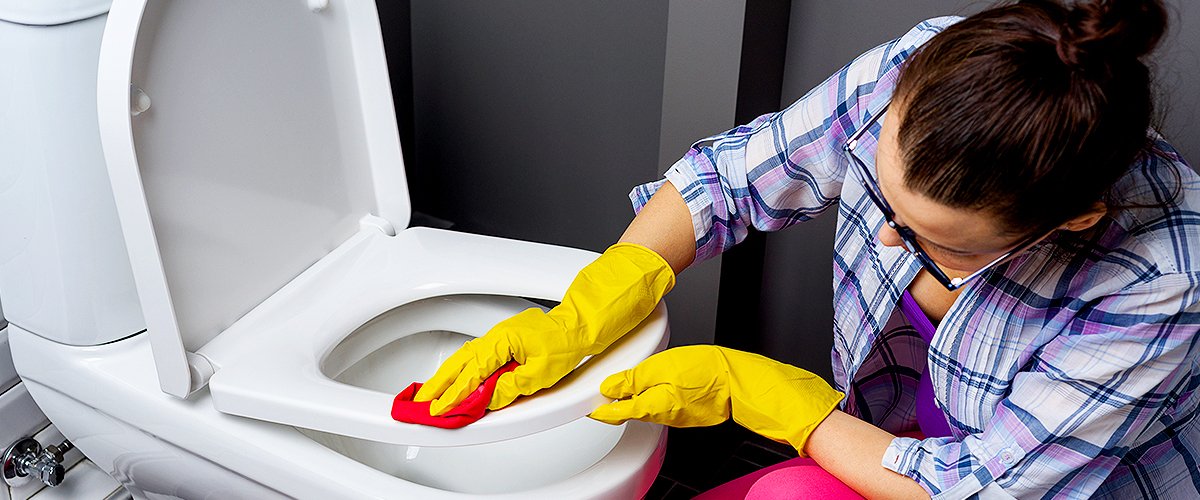 Frau reinigt eine Toilette | Quelle: Shutterstock